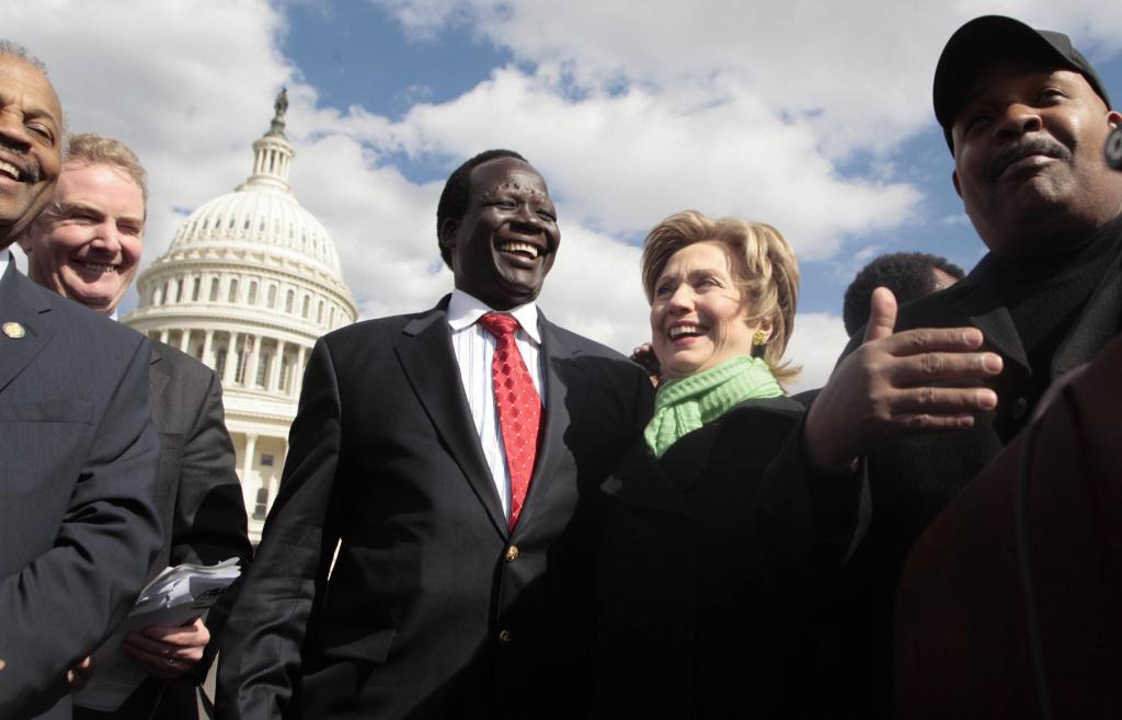 Simon Deng, former Sudanese slave, and US Senator Hillary Clinton, along with other recognized individuals, attending a rally at the US Capitol commemorating the end of Deng's 300 mile Sudan Freedom Walk