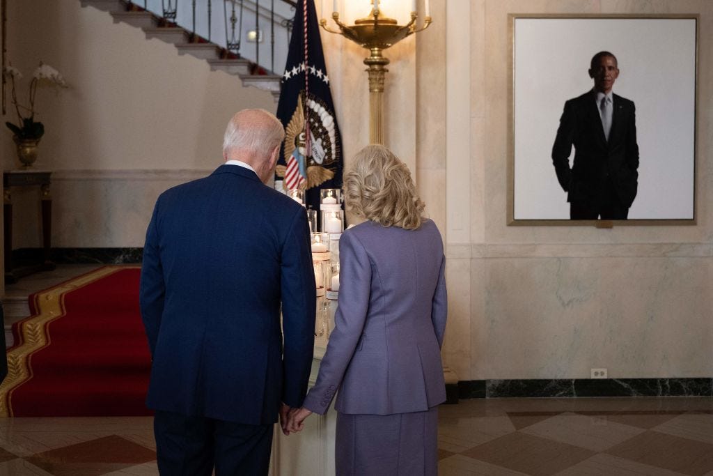 The Bidens stand next to a portrait of Barack Obama at the White House.