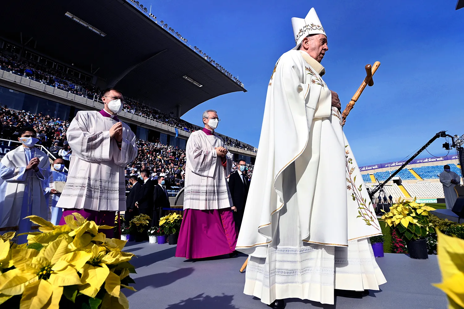 Pope Francis walks at a football stadium in Cyprus
