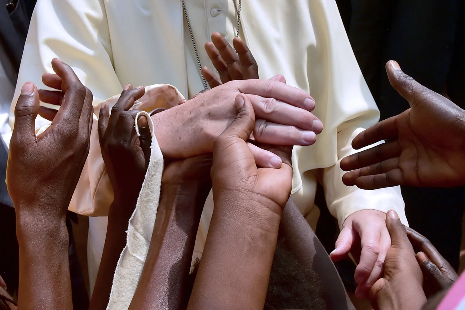 Children touch the hands of Pope Francis