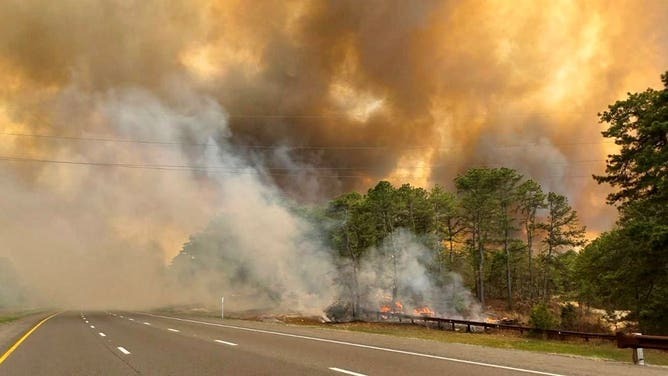 Flames from the Jones Road Fire in Barnegat, New Jersey, consuming over 1,200 acres near the Garden State Parkway, prompting evacuations on April 22, 2025.