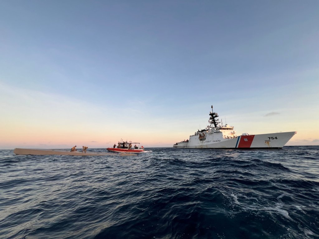 U.S. Coast Guard law enforcement officers boarding a low profile vessel in the Eastern Pacific Ocean, representing a significant drug seizure operation