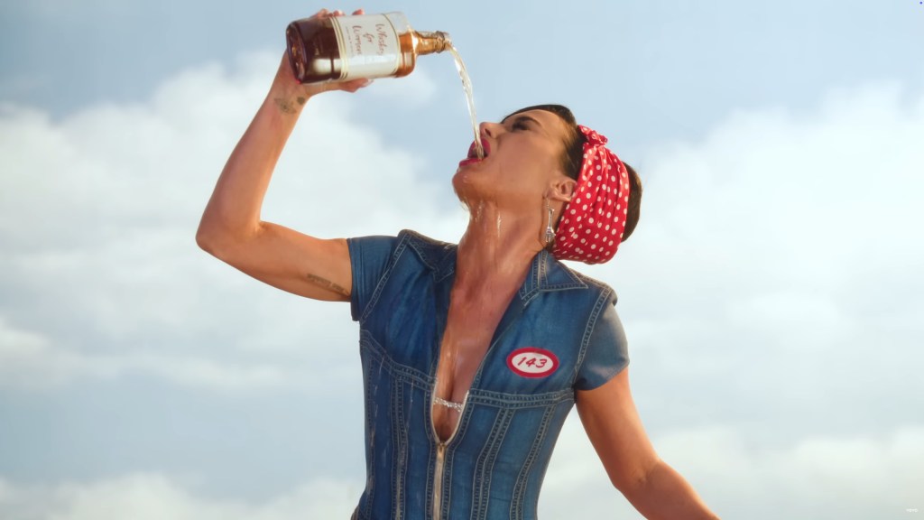Katy Perry holding a bottle of alcohol above her head and pouring it into her mouth