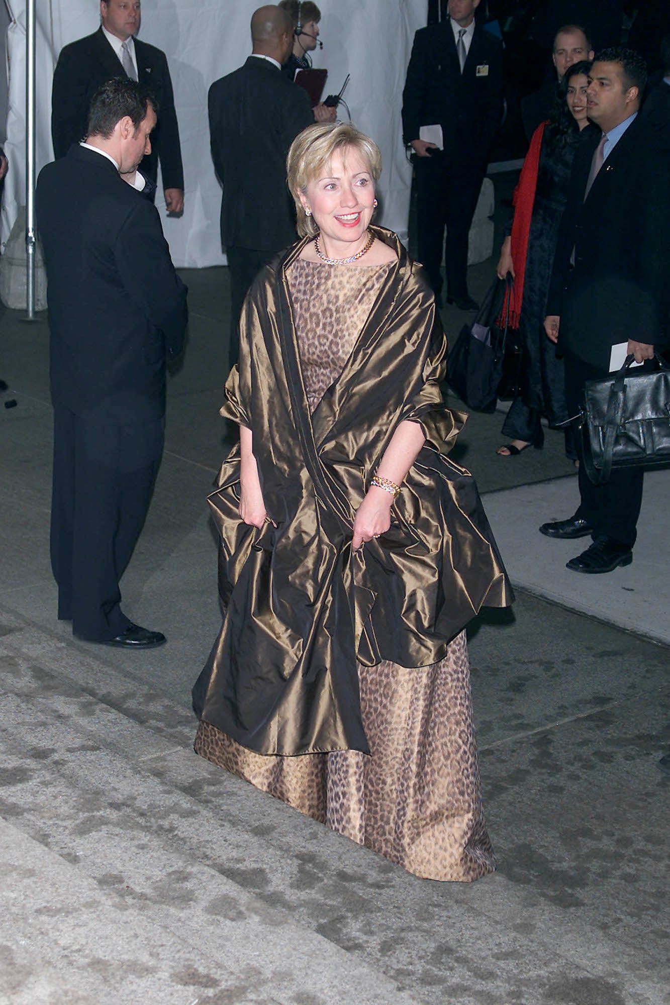 Hillary Clinton, dressed in a cheetah-print gown with a bronze shawl draped around her shoulders, enters the Met Gala in 2001.