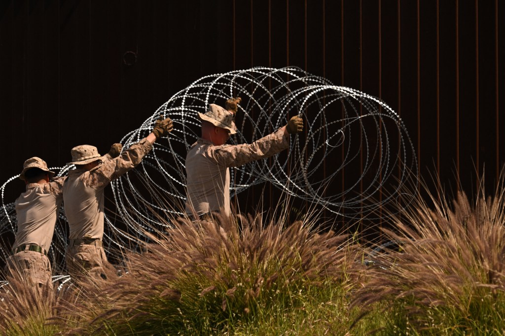 Service members install concertina wire along the border in San Ysidro, California.