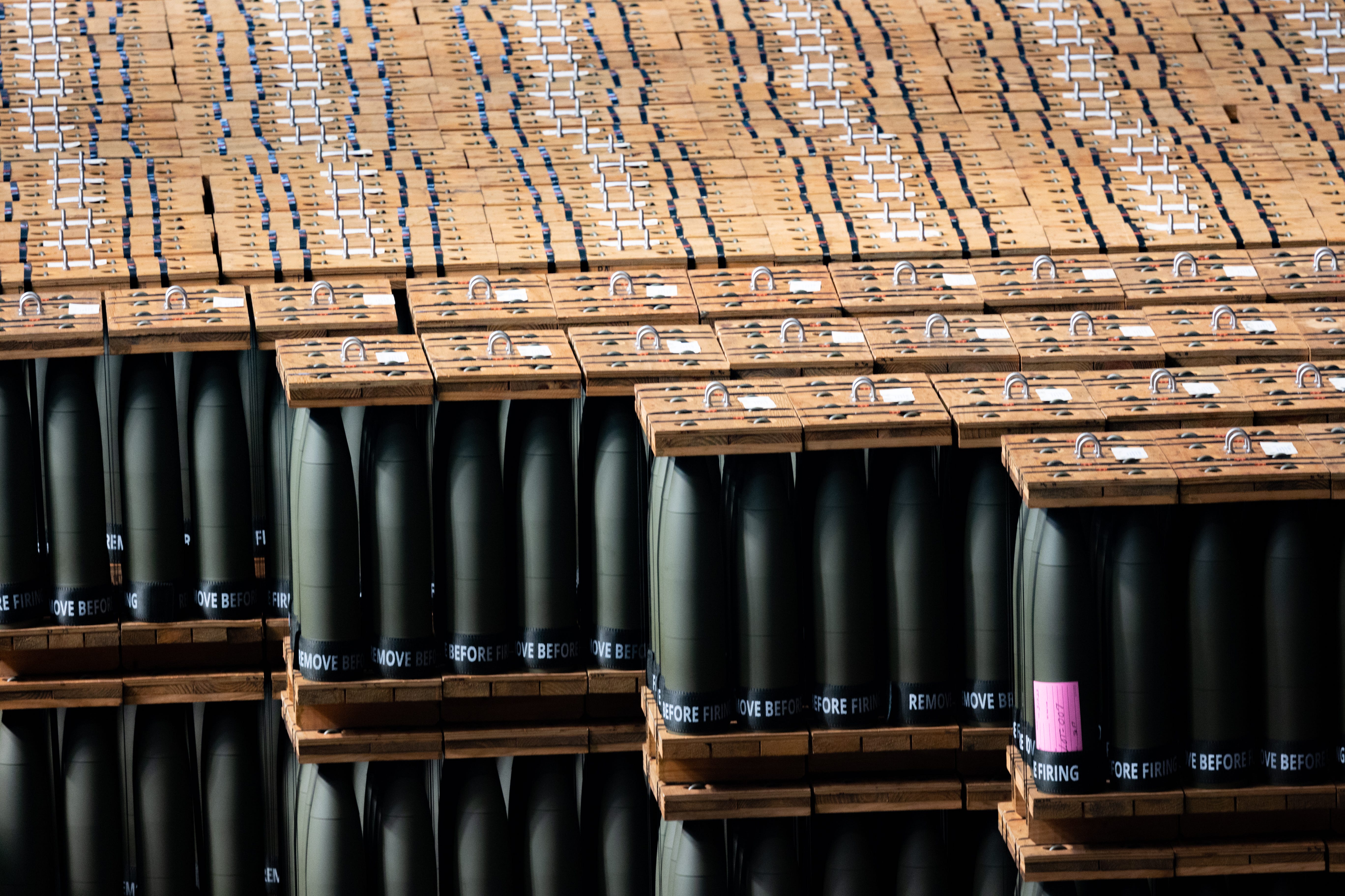 Various artillery rounds are seen packed in between wooden planks.