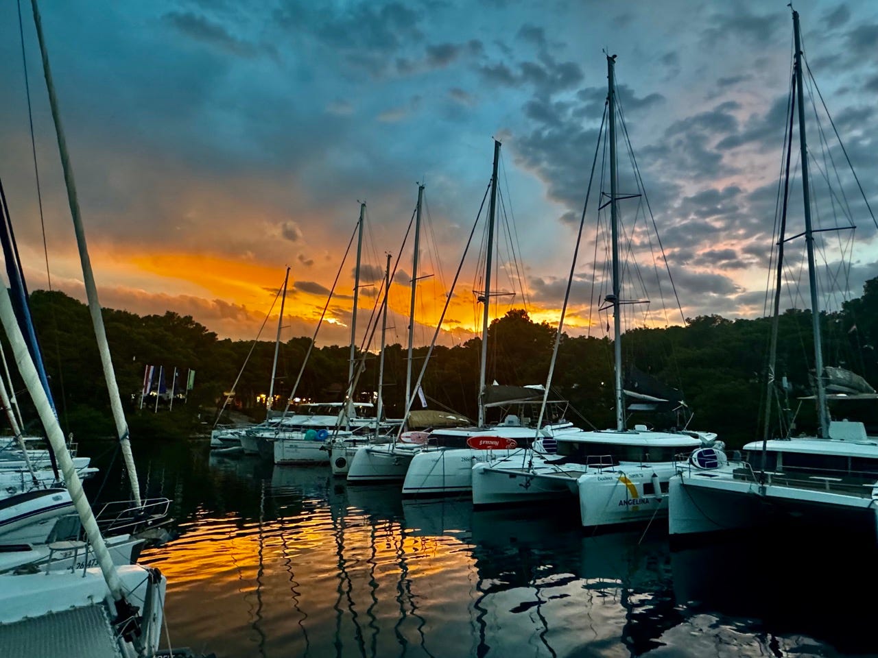 Various sailboats docked at a marina in Palmizana, Hvar, at sunset 