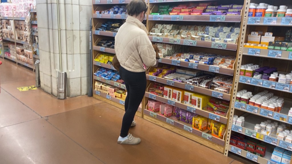 A woman holds her dog in Trader Joe's.