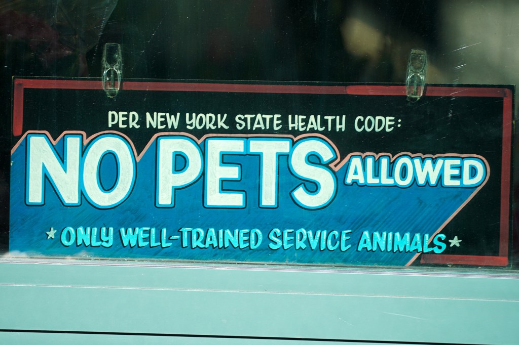 A sign warning against dogs in the store.