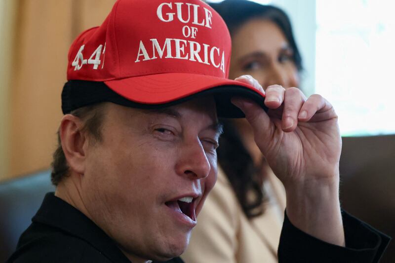 Tesla CEO Elon Musk reacts while wearing a cap with the words "Gulf of America" as he attends a cabinet meeting held by U.S. President Donald Trump at the White House.