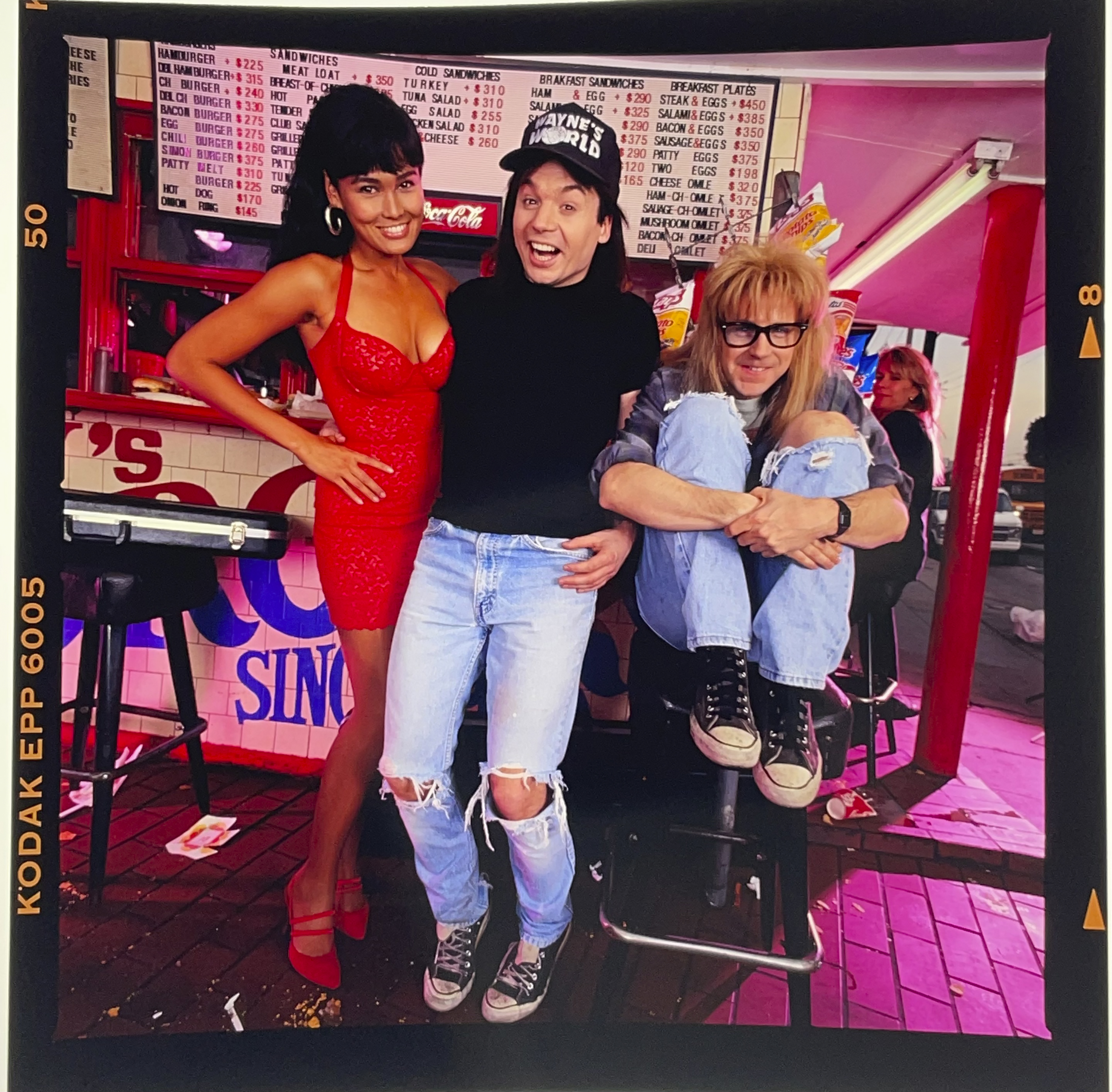 Tia Carrere in a red dress with Mike Myers and Dana Carvey. 