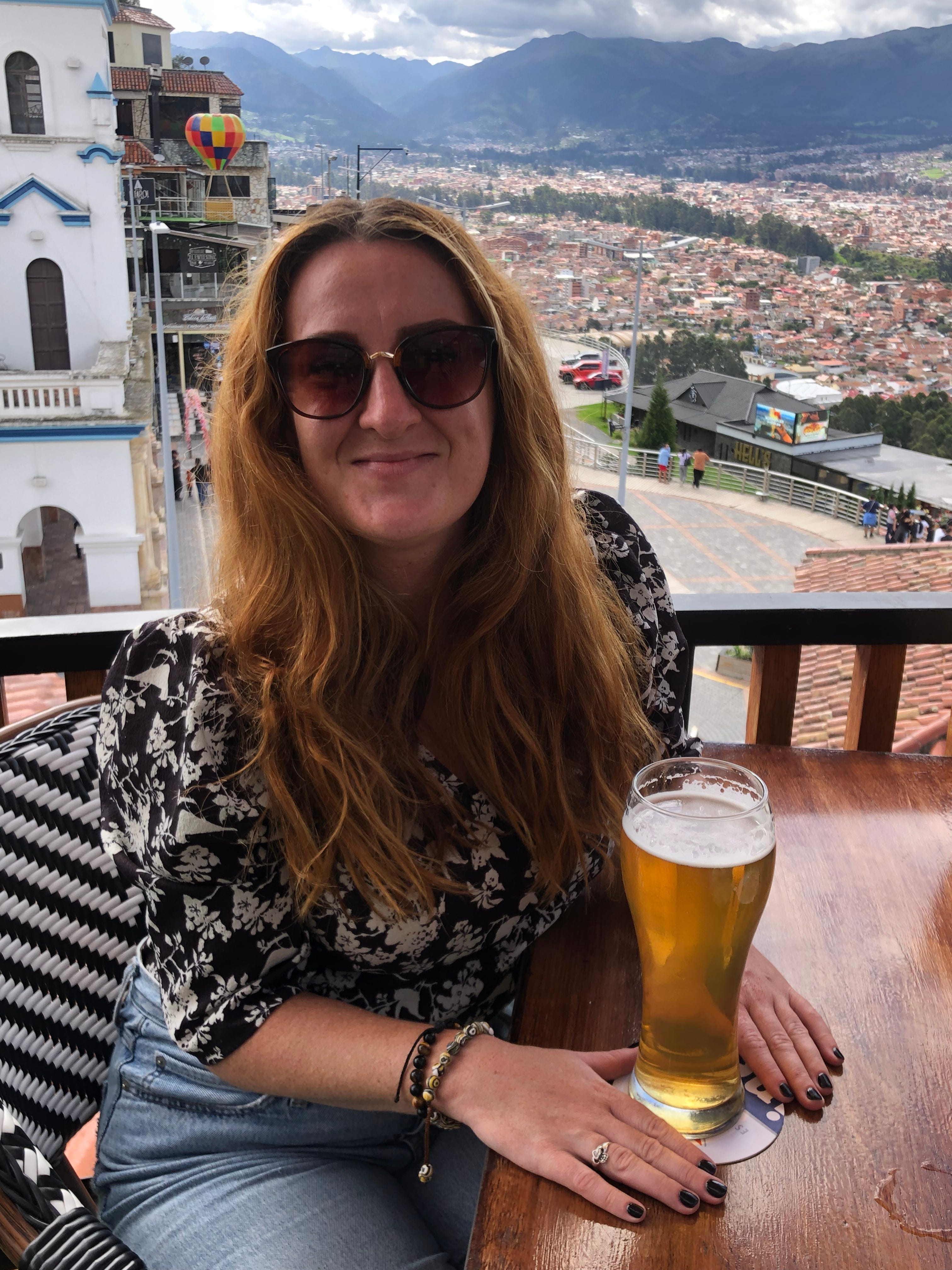 A woman sitting at a bar in Ecuador having a beer.