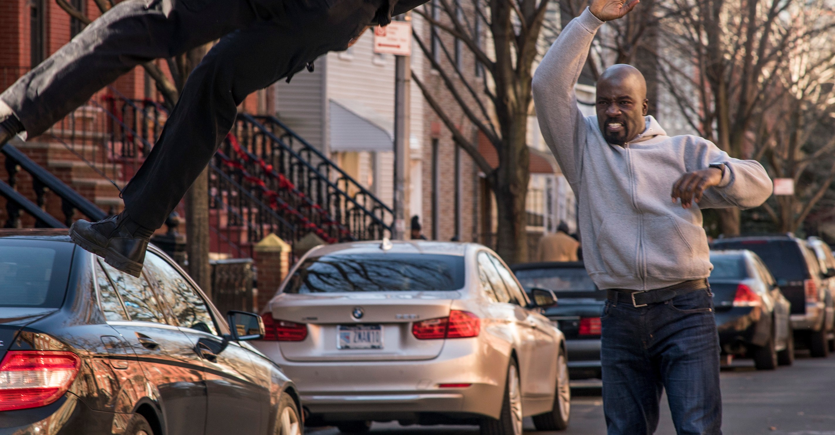 Luke Cage throws a bad guy in the street