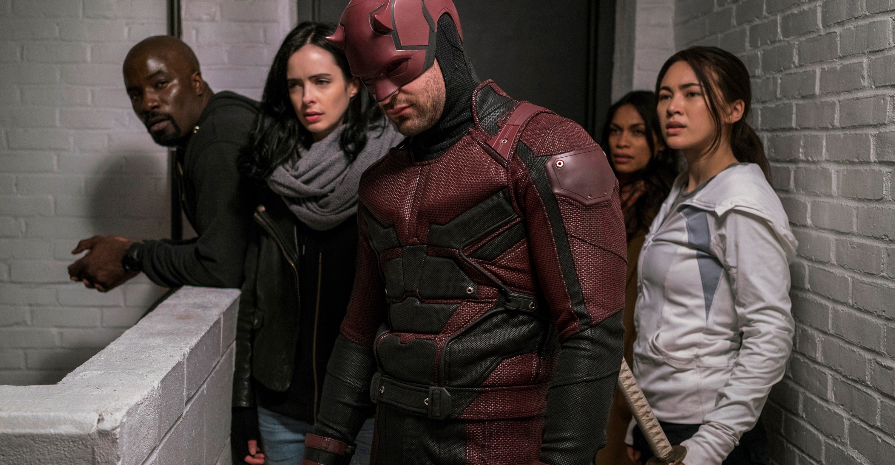 Luke Cage, jessica Jones, Daredevil, and Colleen Wing stand in the hallway in The Defenders