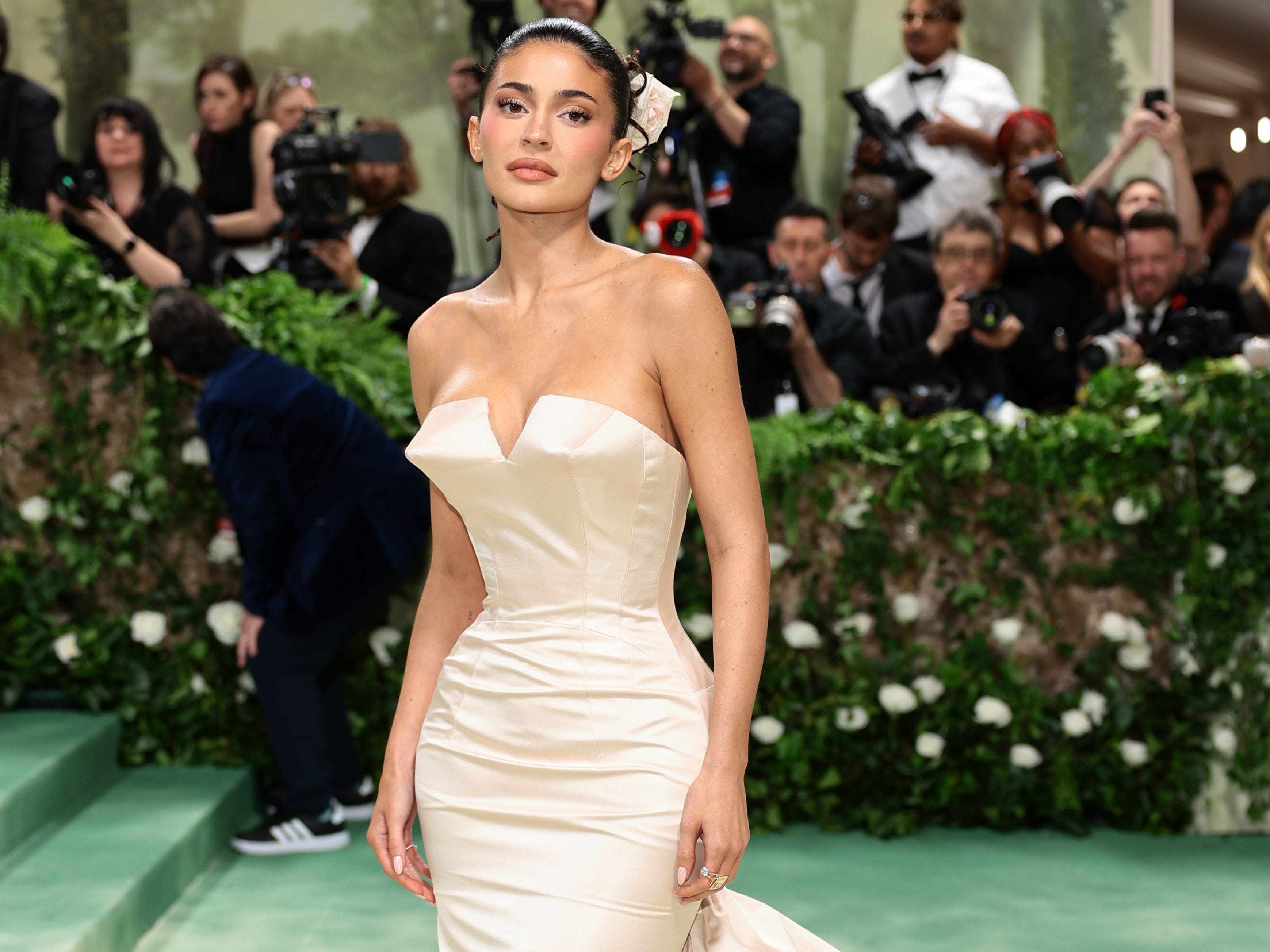 Kylie Jenner posing in a cream dress on the Met Gala arrivals carpet.