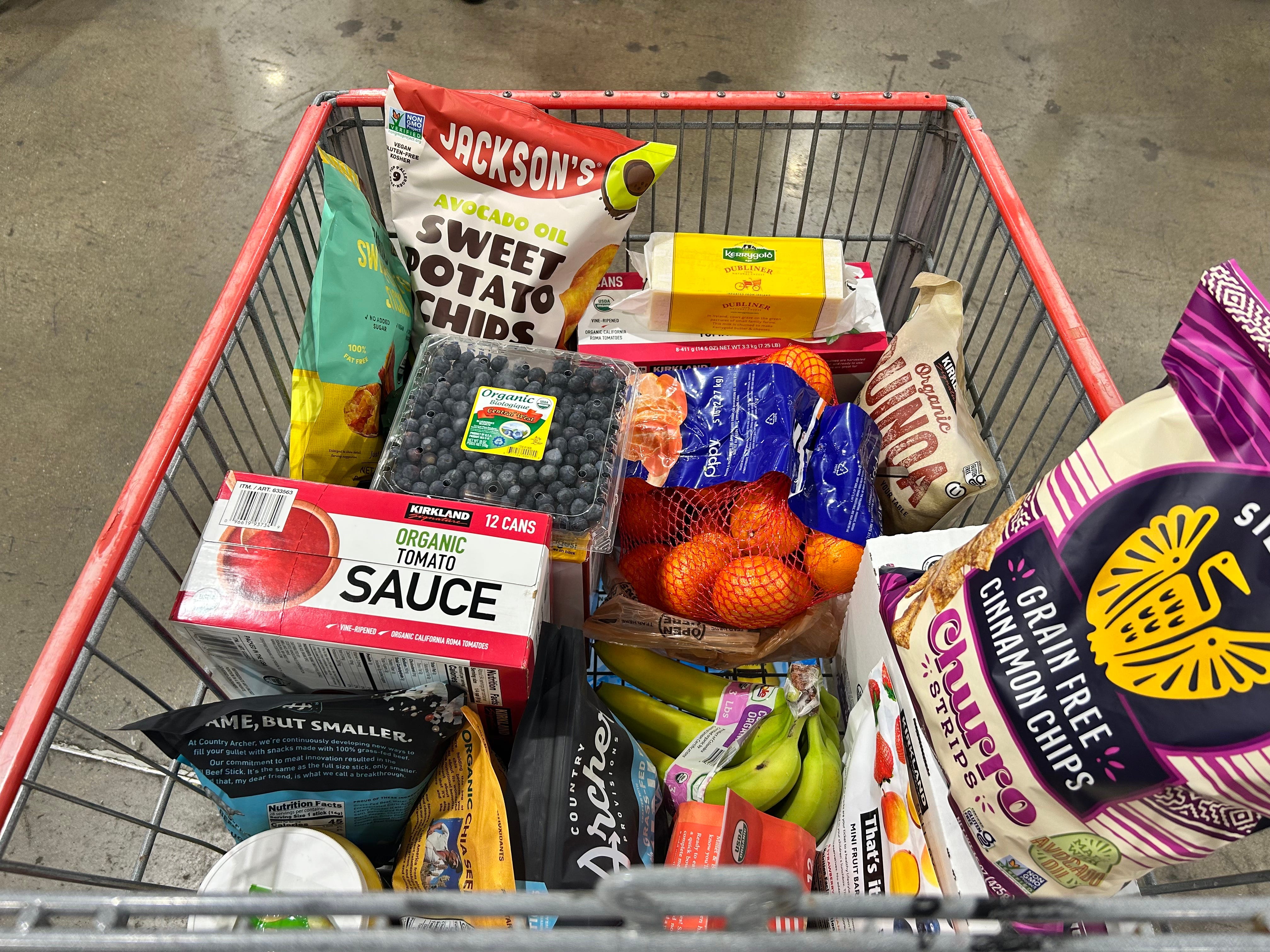 The author's full cart at Costco, filled with items like mandarin oranges, sweet potato chips, and more.