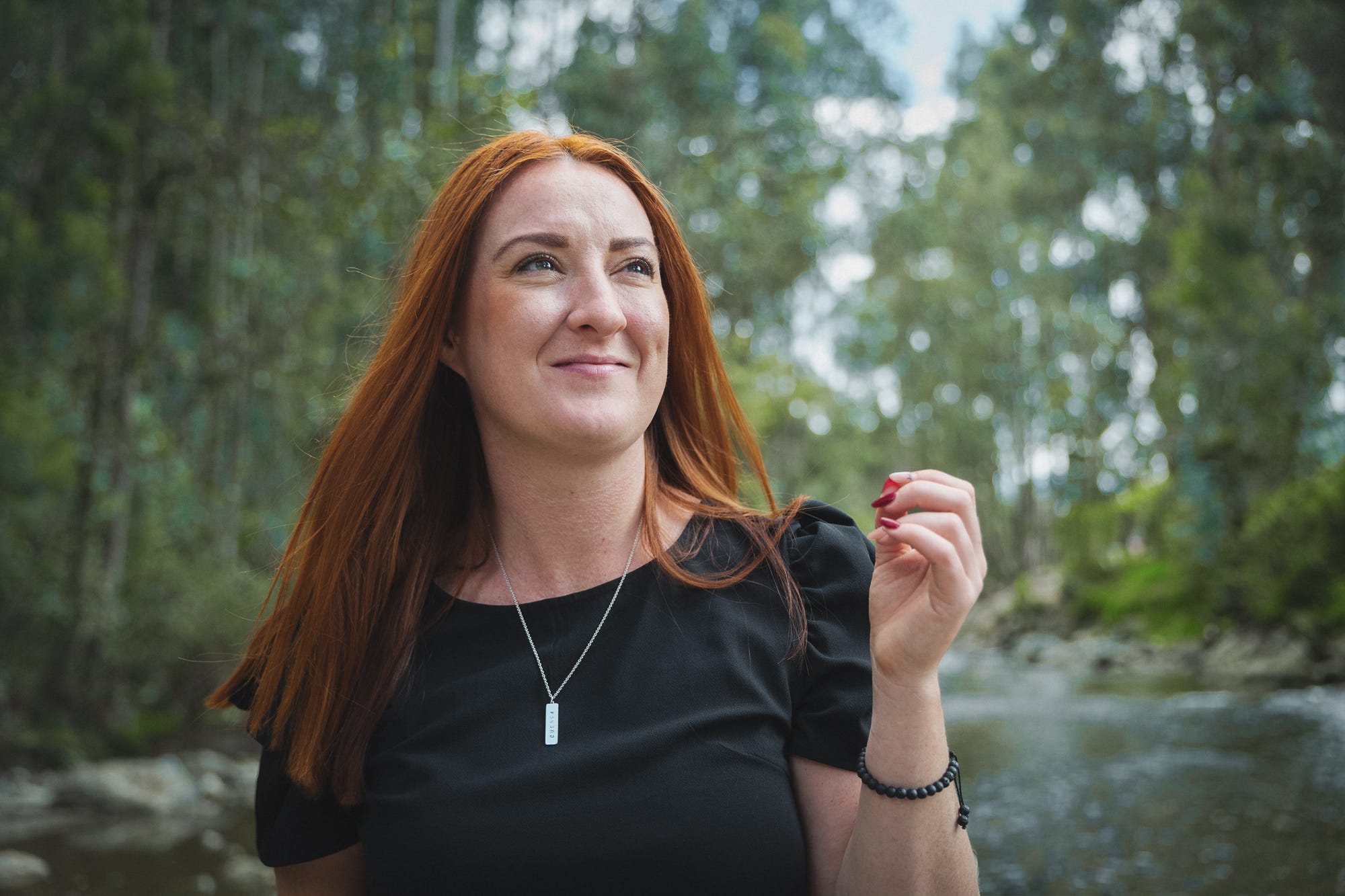 Woman in black shirt near a river in South America.