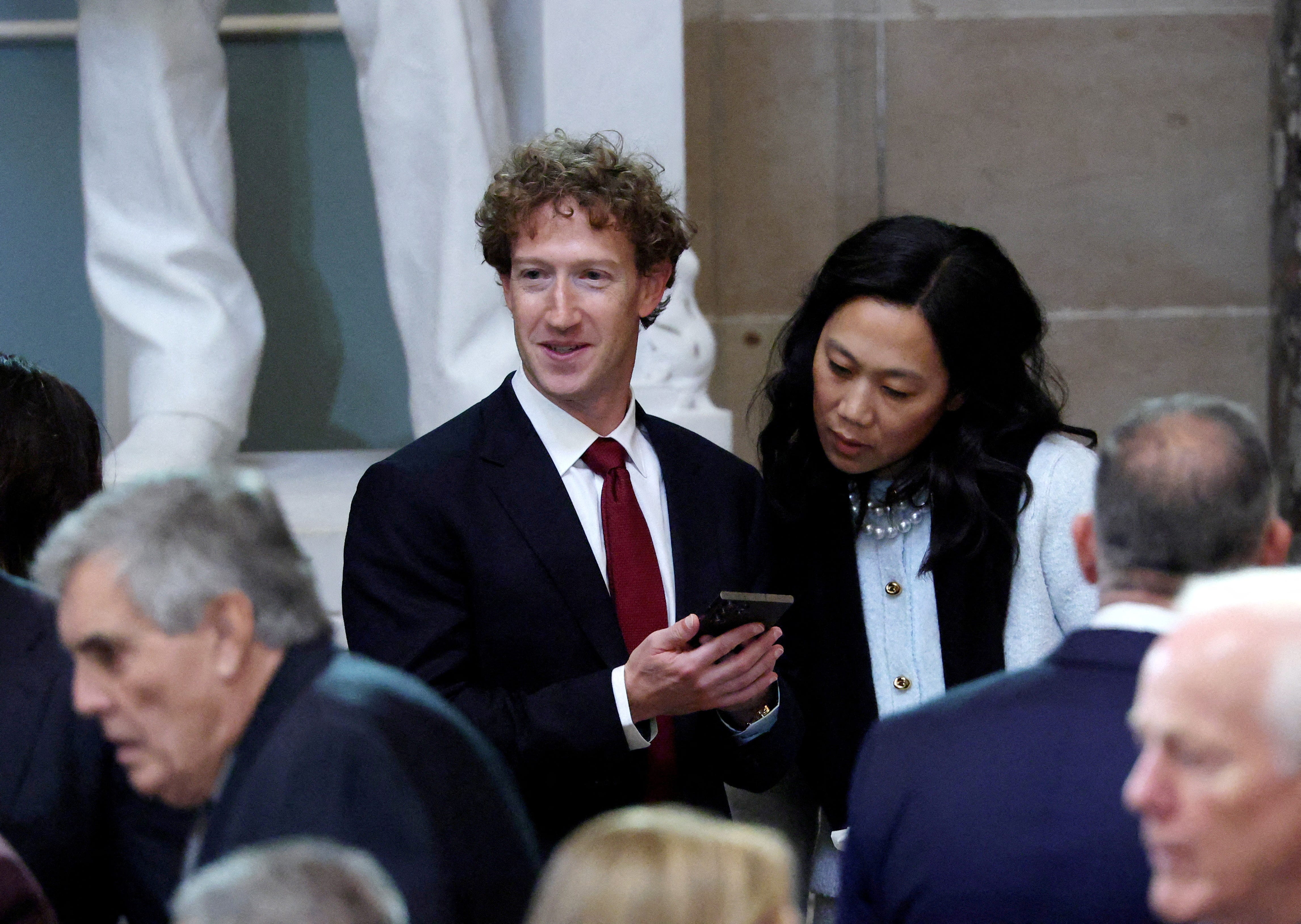 Mark Zuckerberg holding a phone