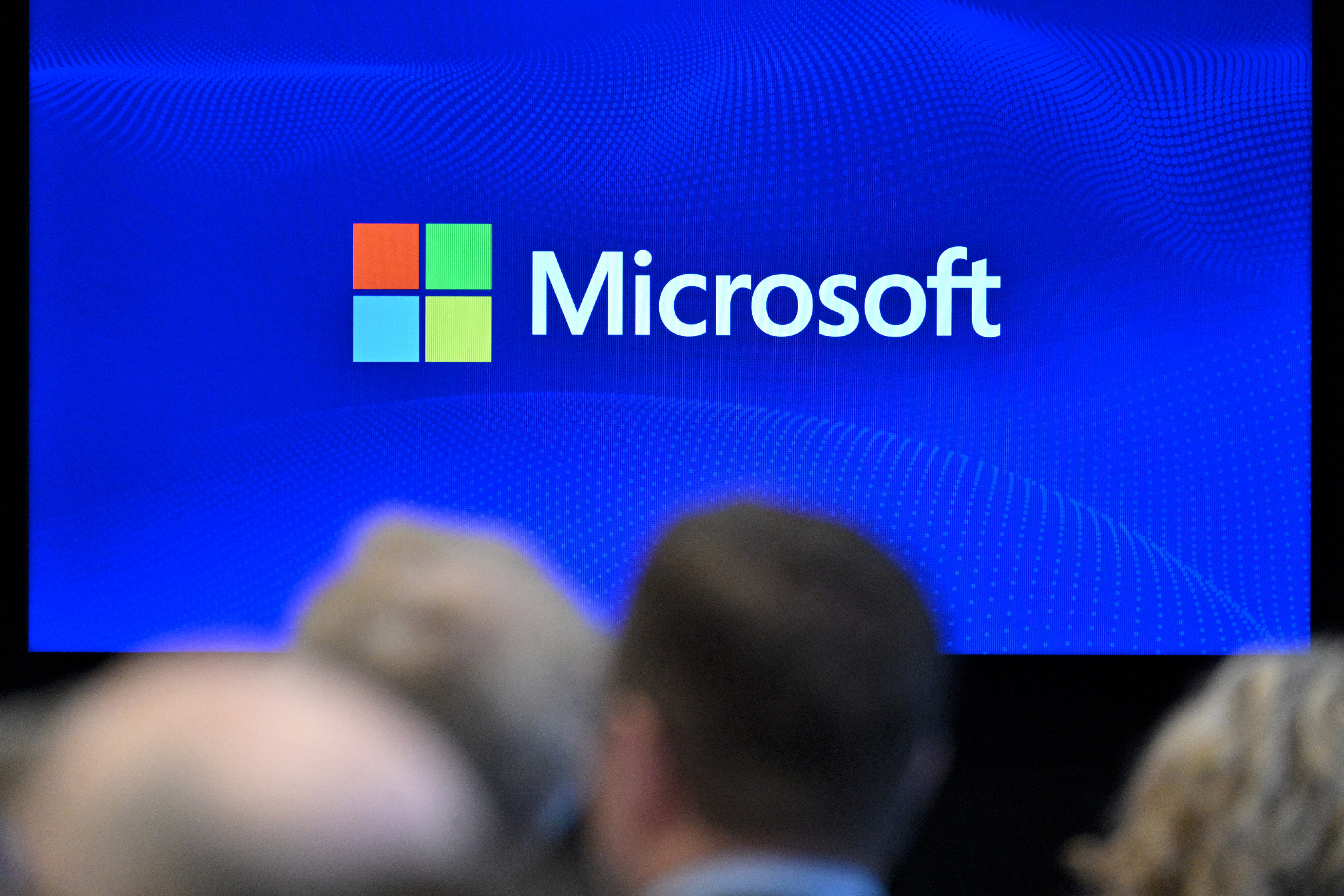 he Microsoft logo is displayed on a screen during a speech by Microsoft vice-chair and president in Brussels on April 30, 2025.