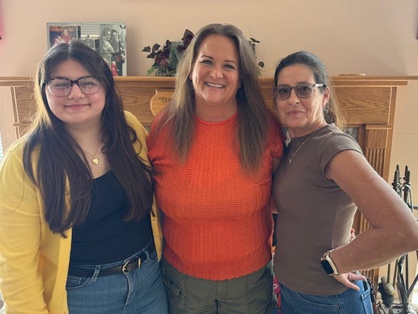 The author of the essay poses with two family members.