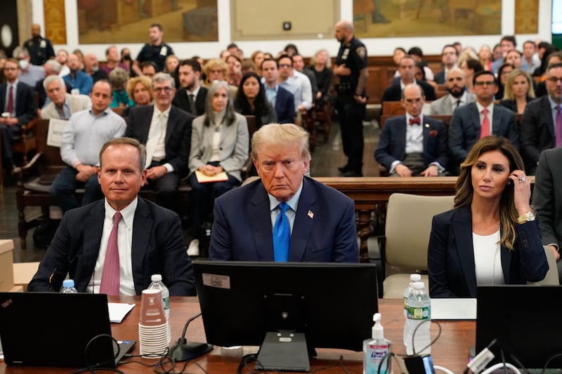 Donald Trump sitting between his lawyers at his fraud trial in October 2023.