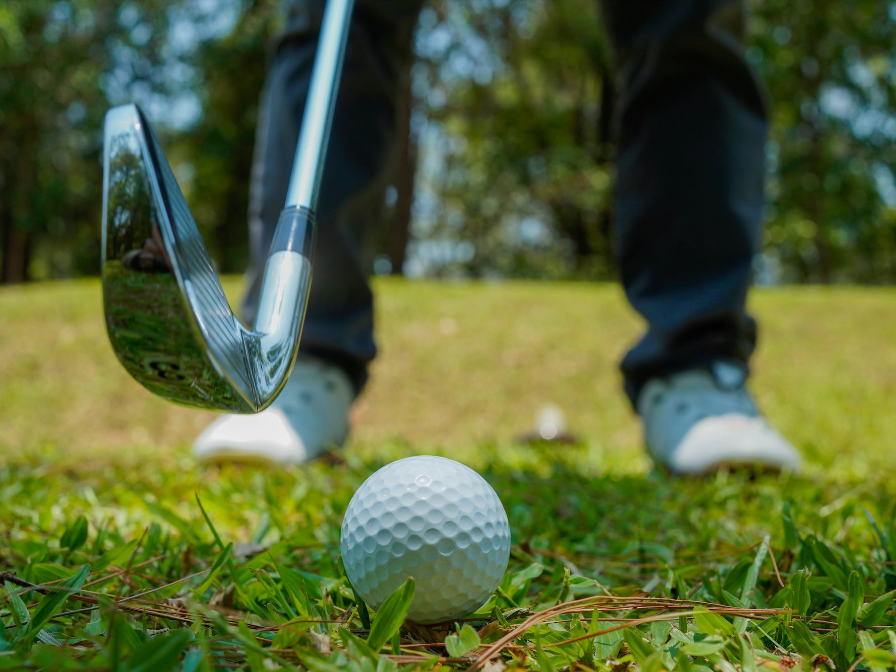 A golfer preparing to swing a club at a ball.