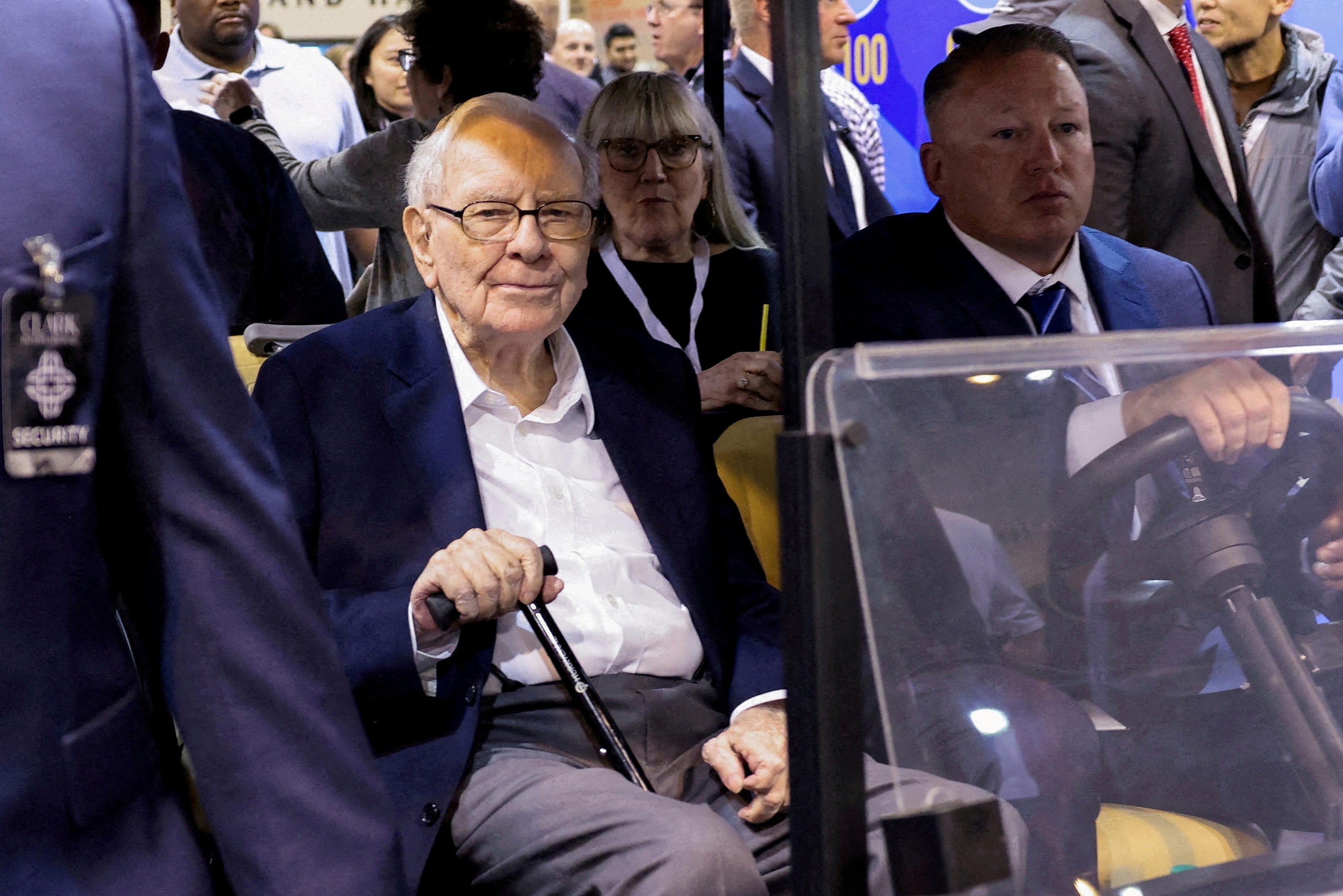 Warren Buffett riding in a golf cart