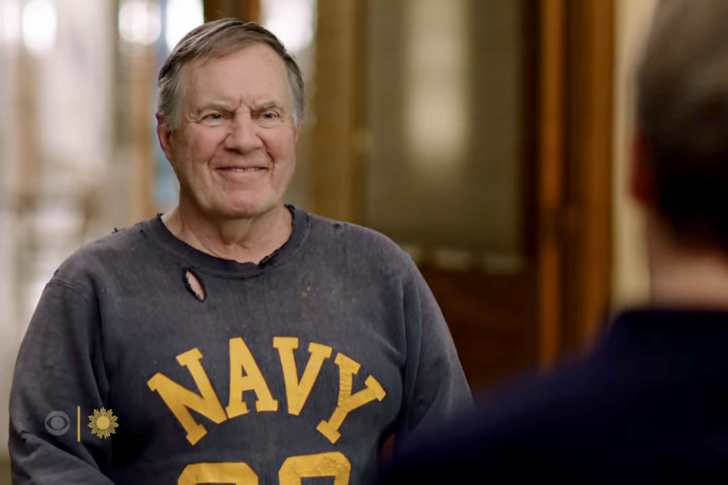 Bill Belichick sits for an interview in a Navy sweatshirt. 