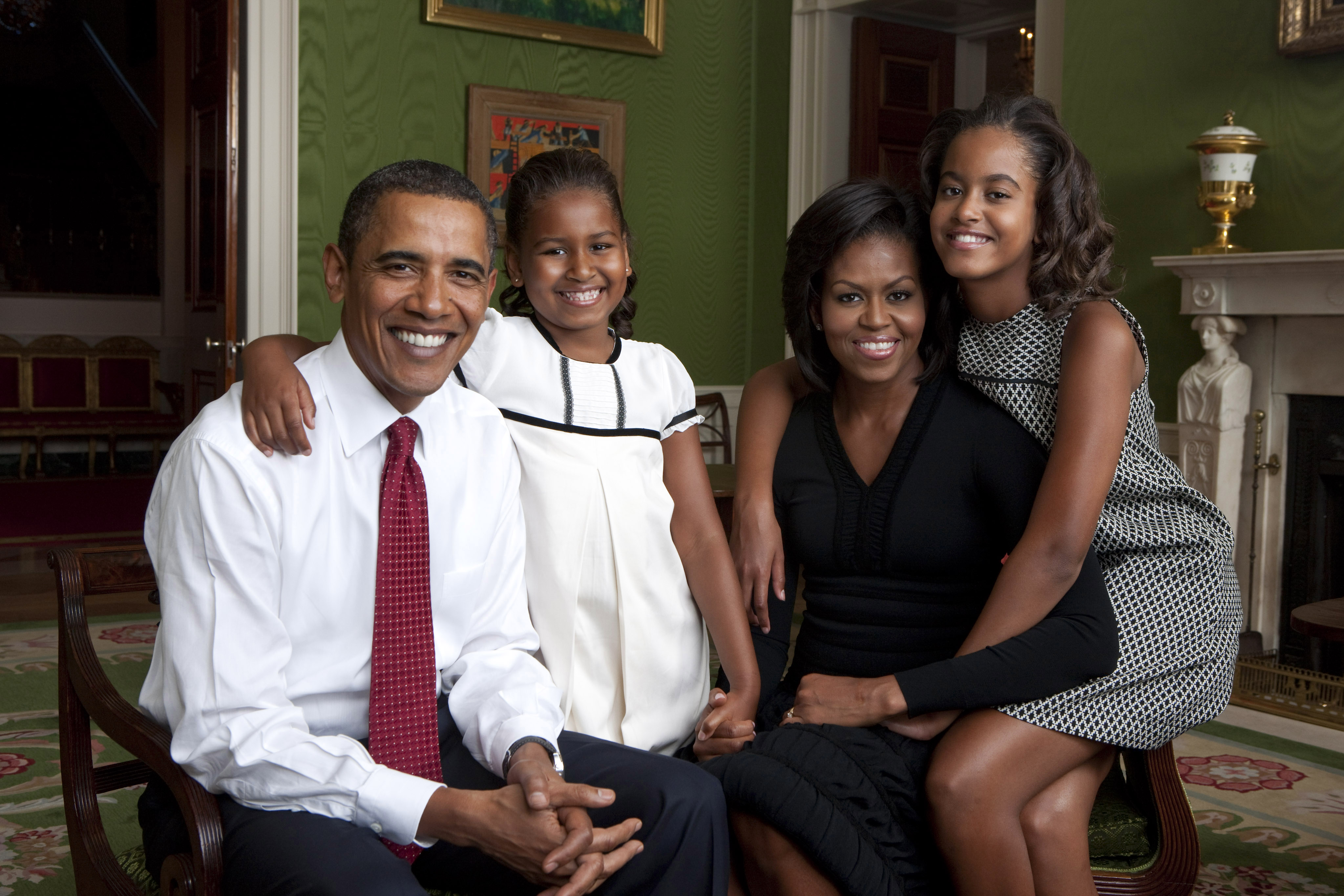 Barack and Michelle Obama pose at home with their two daughters, Sasha and Malia. 