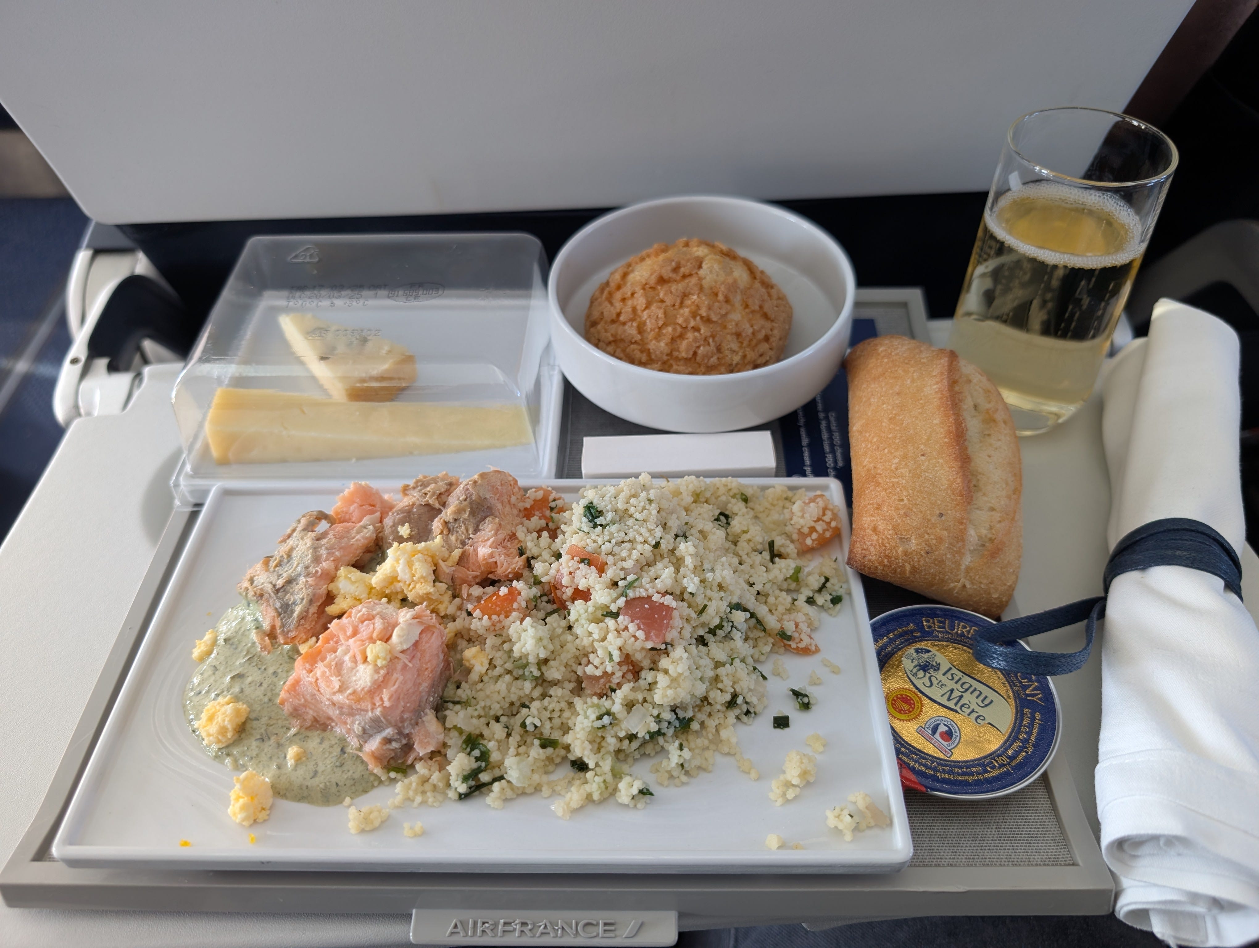 rice with roll, cheese, champagne, on tray table on flight