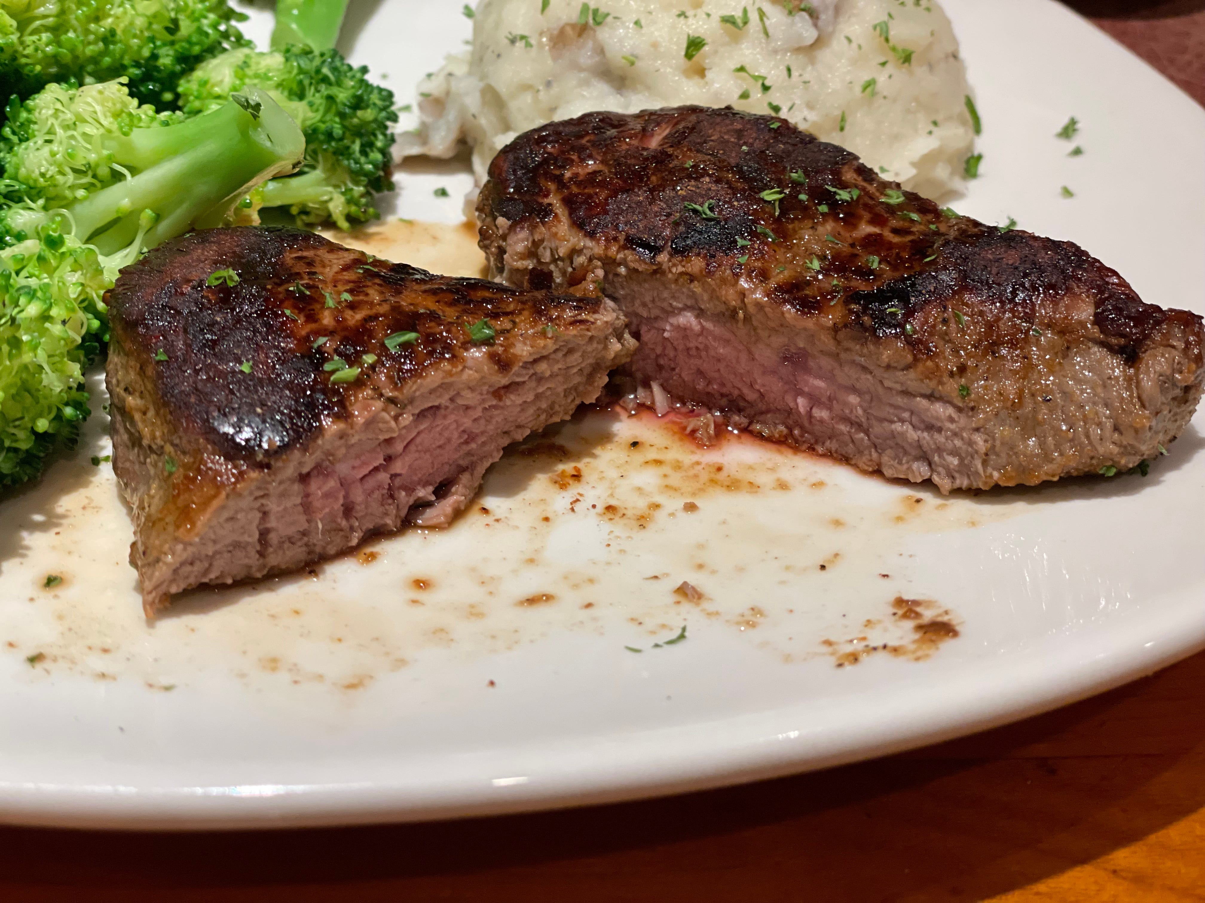 Outback steakhouse cut in half with some pink in the middle