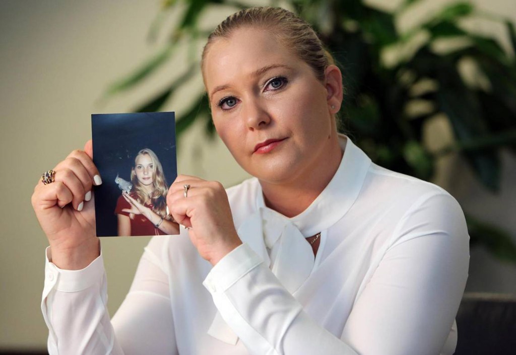 Virginia Giuffre holding a photo of her younger self.