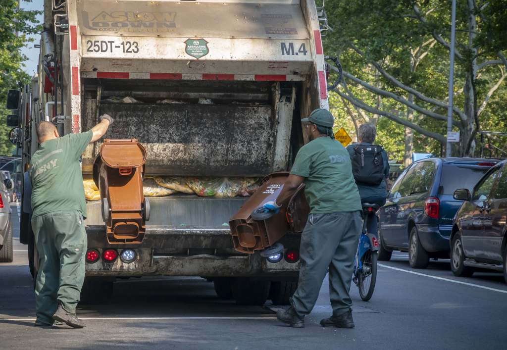 New York Dept. of Sanitation workers empty compost bins for the Organic Waste Collection program outside of an apartment building in the Chelsea neighborhood of New York.
