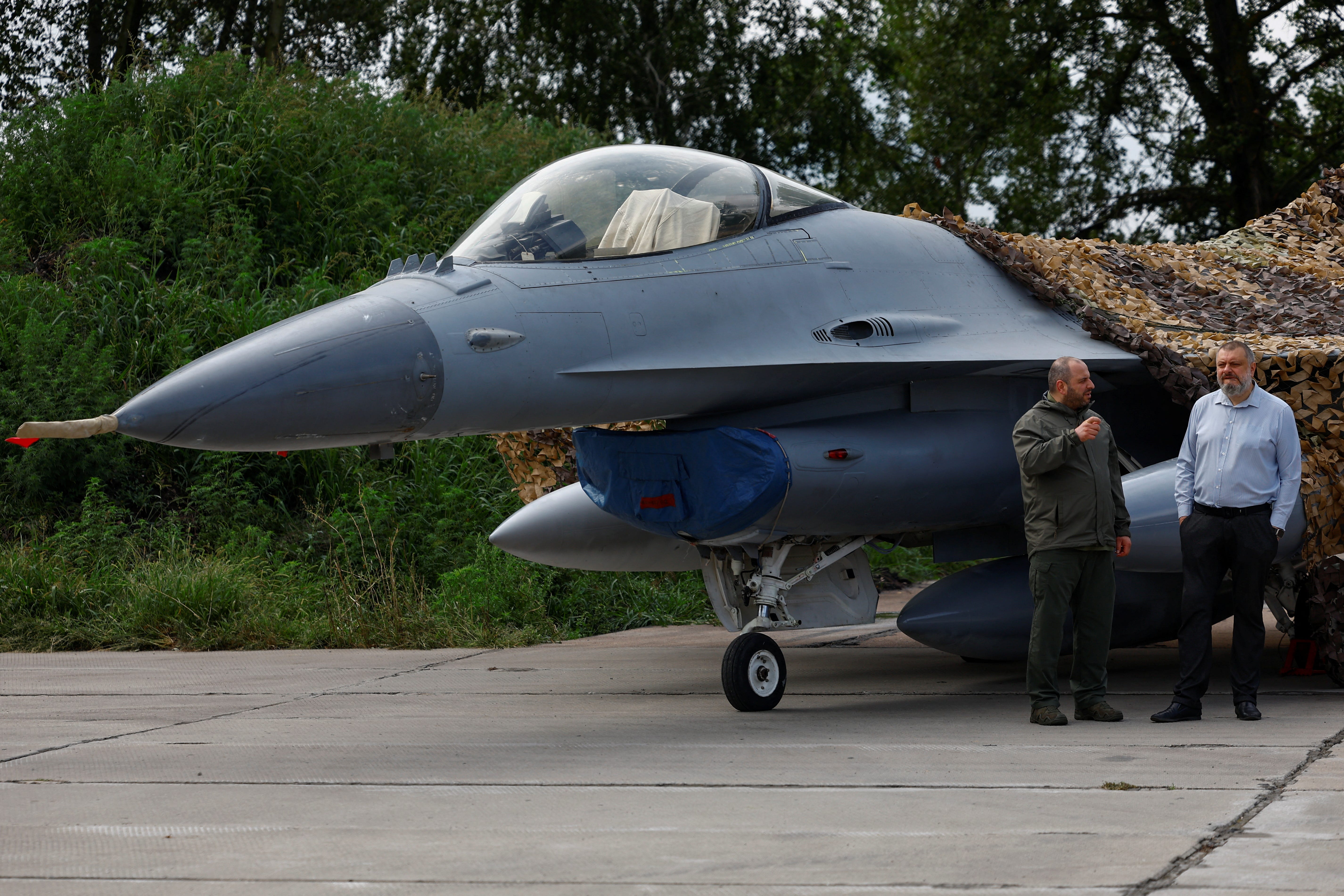 Ukrainian Defence Minister Rustem Umerov and Secretary of Ukraine's National Security and Defence Council Oleksandr Lytvynenko stand next to an F-16 fighting aircraft of the Ukrainian Air Forces, amid Russia's attack on Ukraine, in an undisclosed location, Ukraine August 4, 2024.