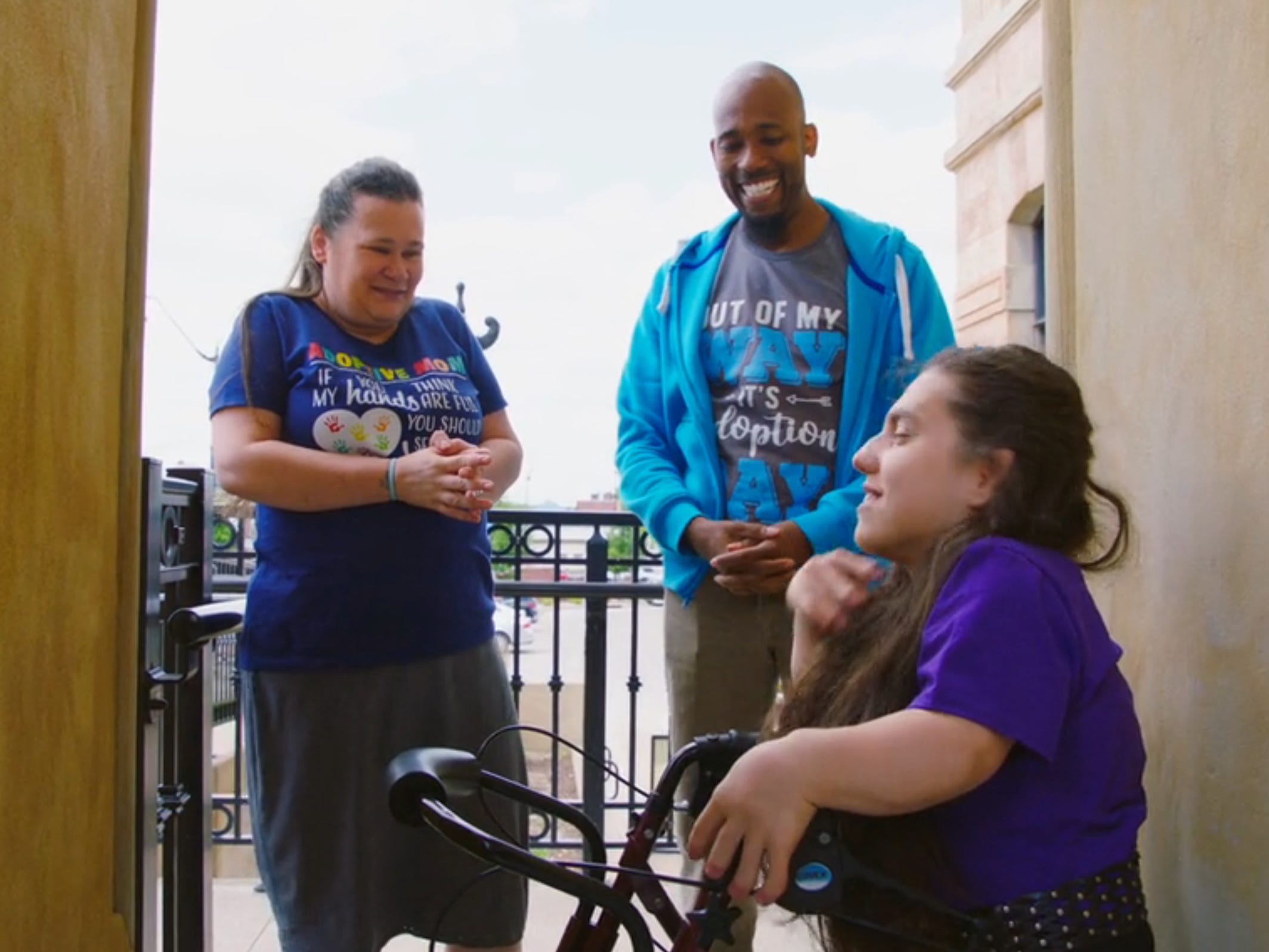 natalia grace barnett stands with antwon mans and cynthia mans, who are both smiling and wearing t-shirts that read