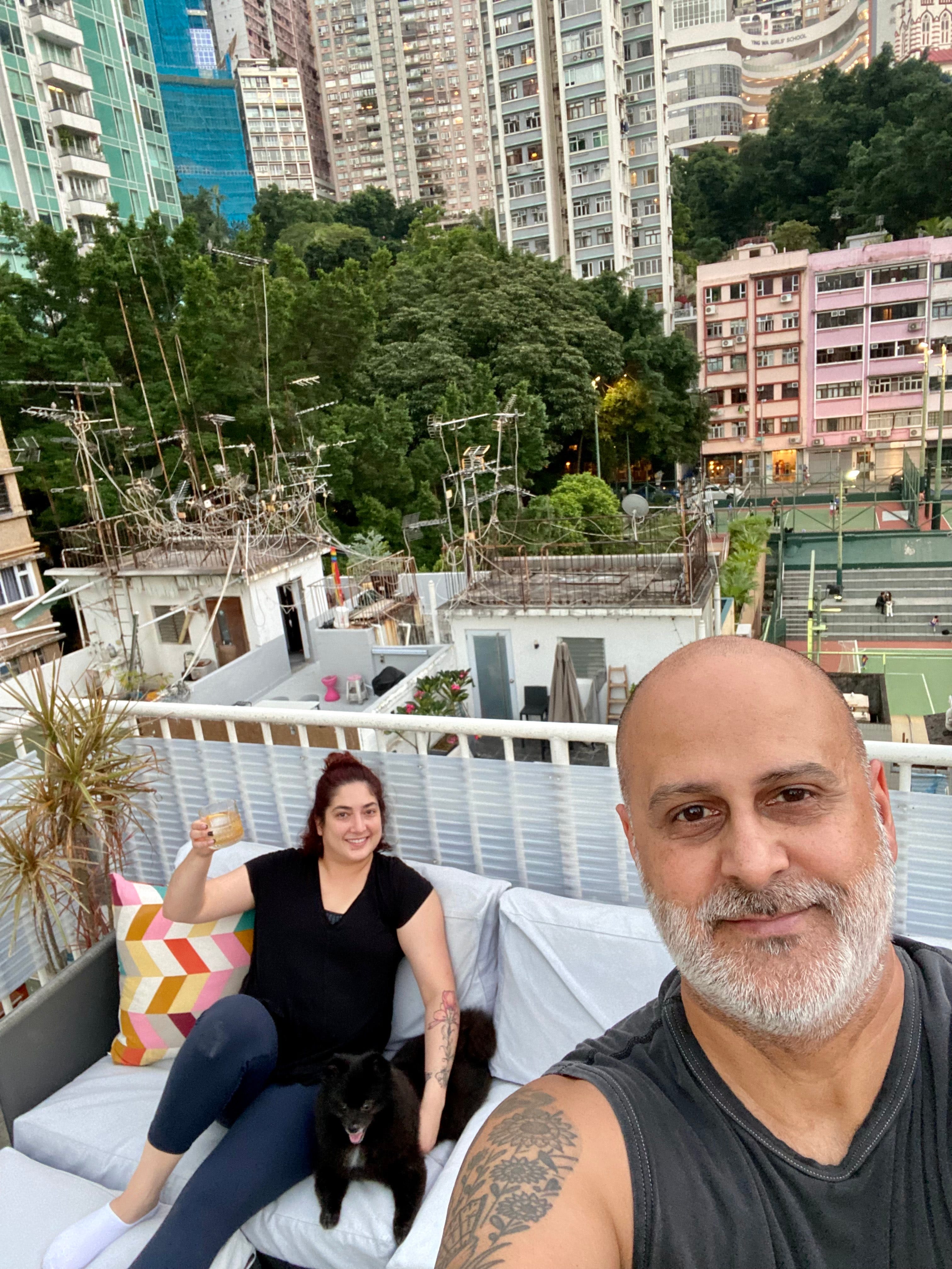 A couple sitting on a rooftop in Hong Kong.