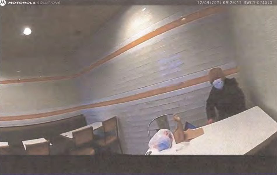 A still photograph from police body-cam footage of Luigi Mangione shows him sitting alone at a McDonalds in Altoona, Pennsylvania shortly before his arrest.