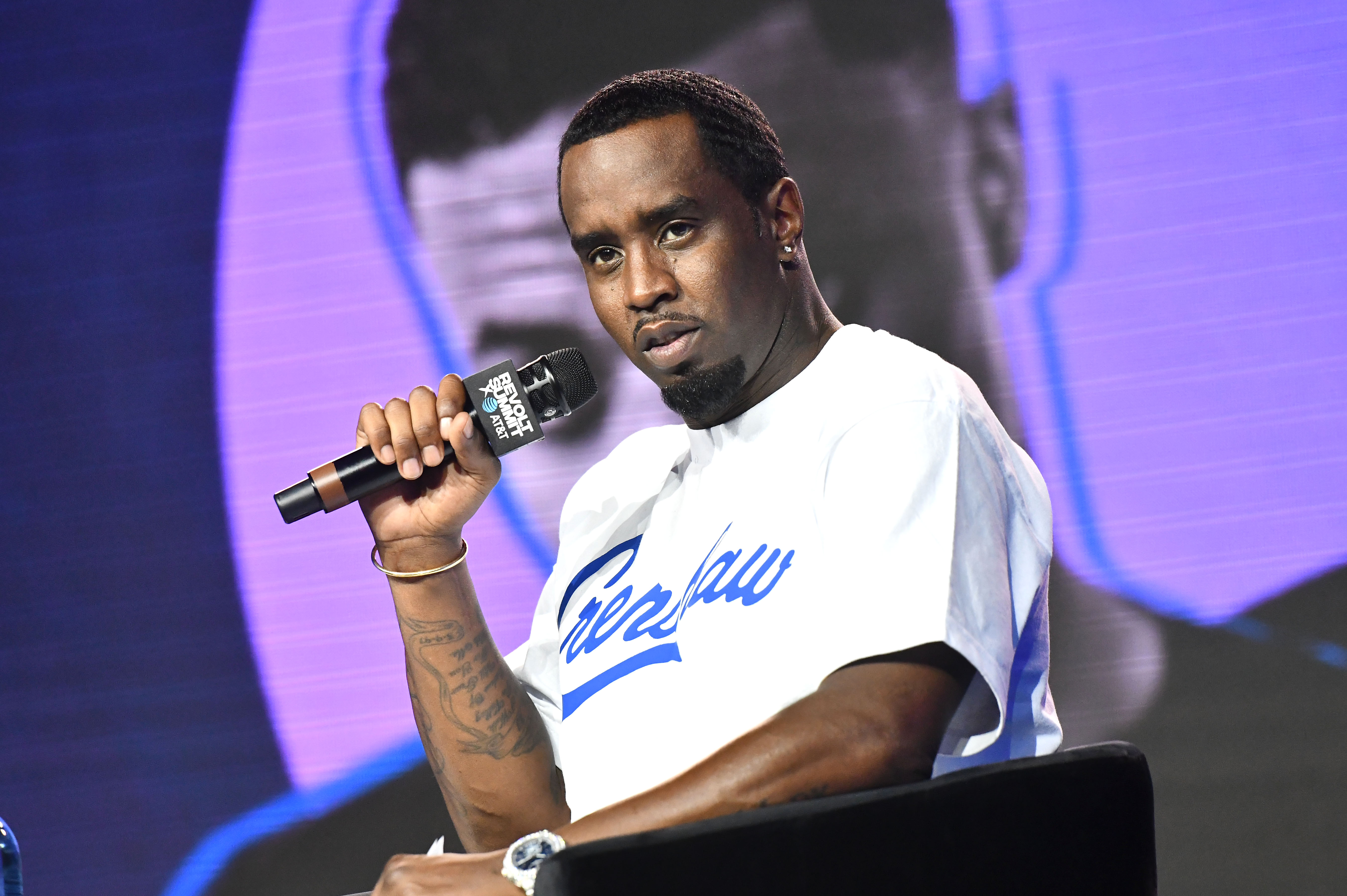 Sean Combs in a baseball jersey with a mic. 
