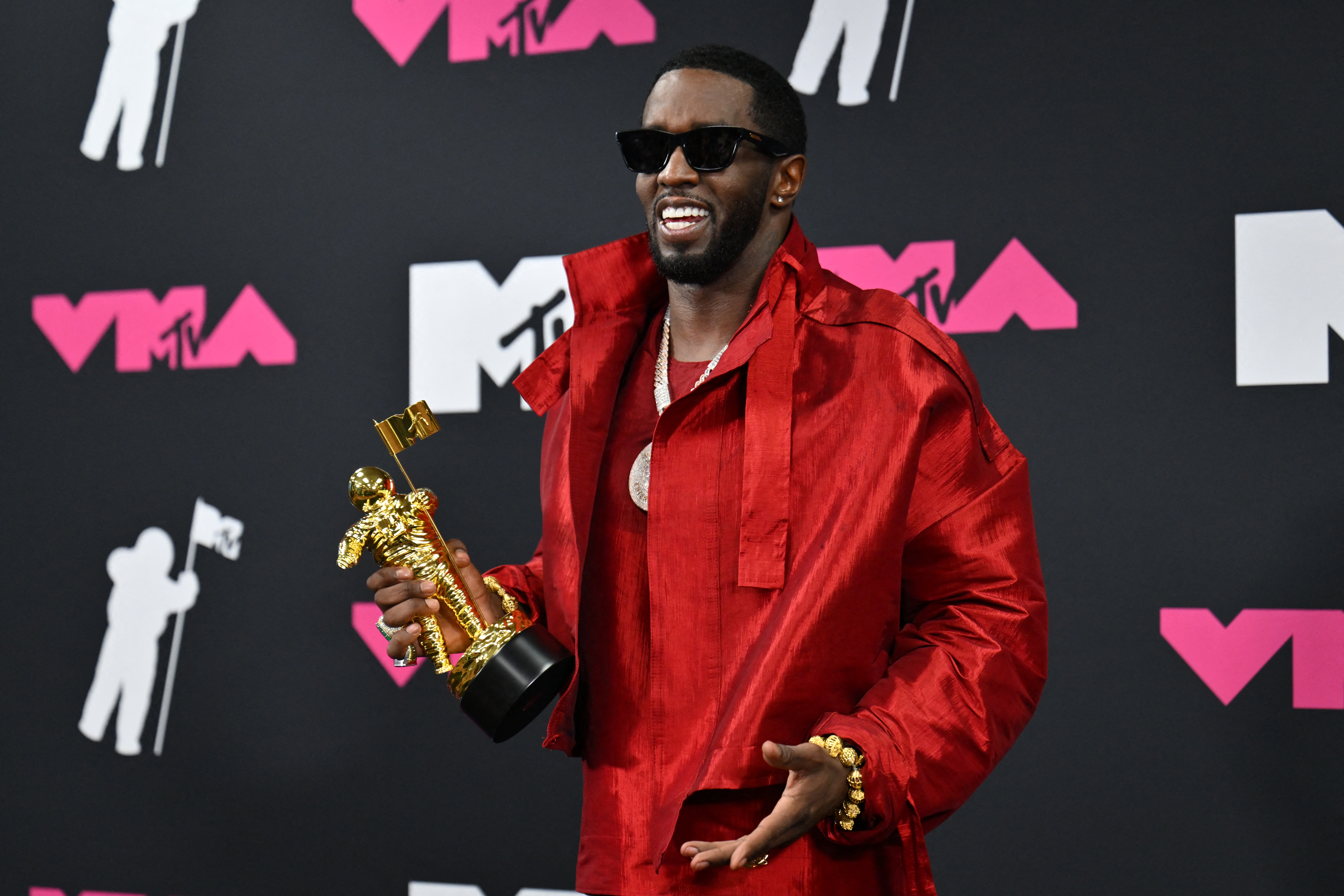 Sean Combs in red with an MTV VMA award. 