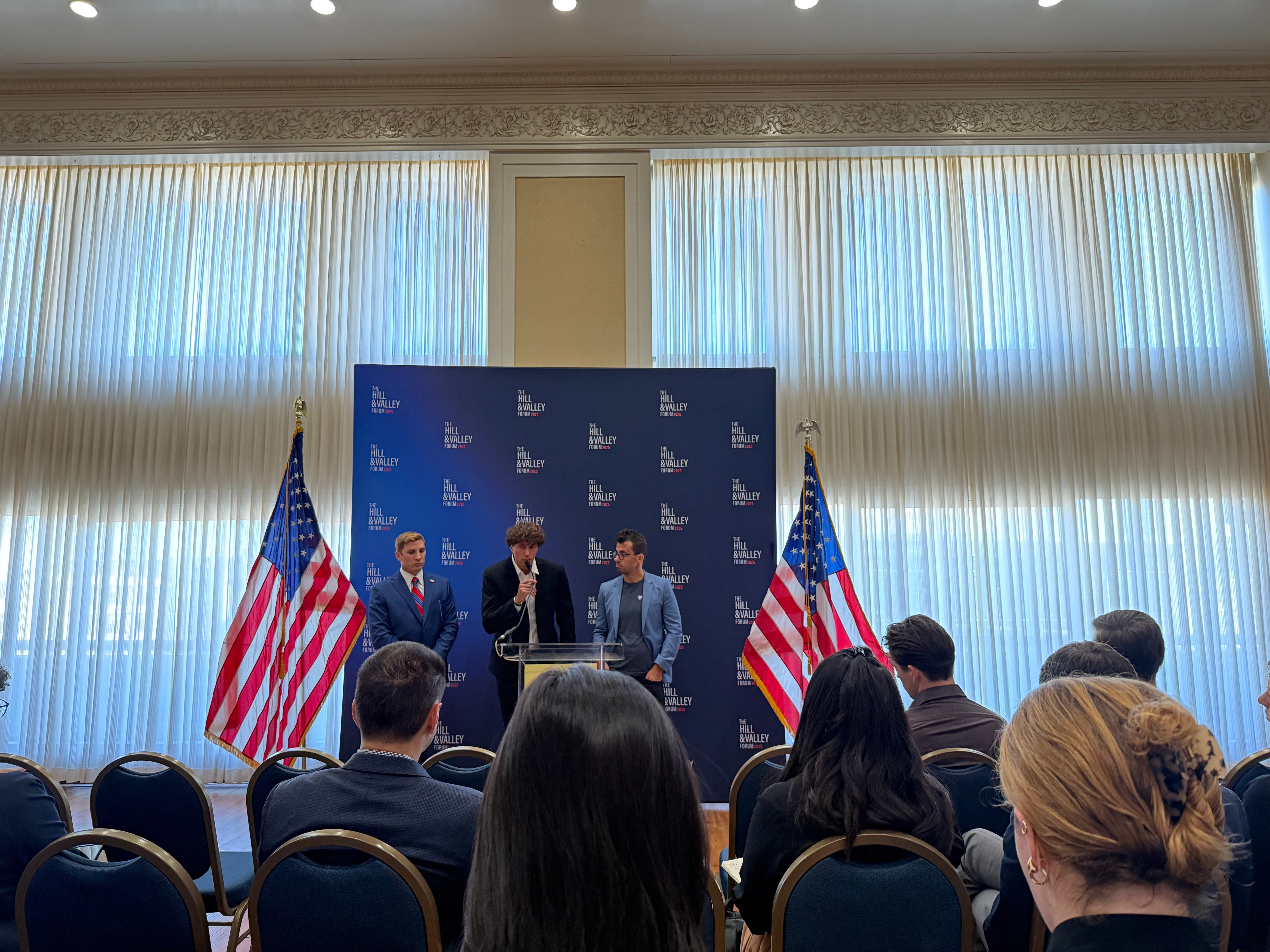 Hill and Valley cofounders Jacob Helberg, Christian Garrett, and Delian Asparouhov speaking at a media event for the Forum.