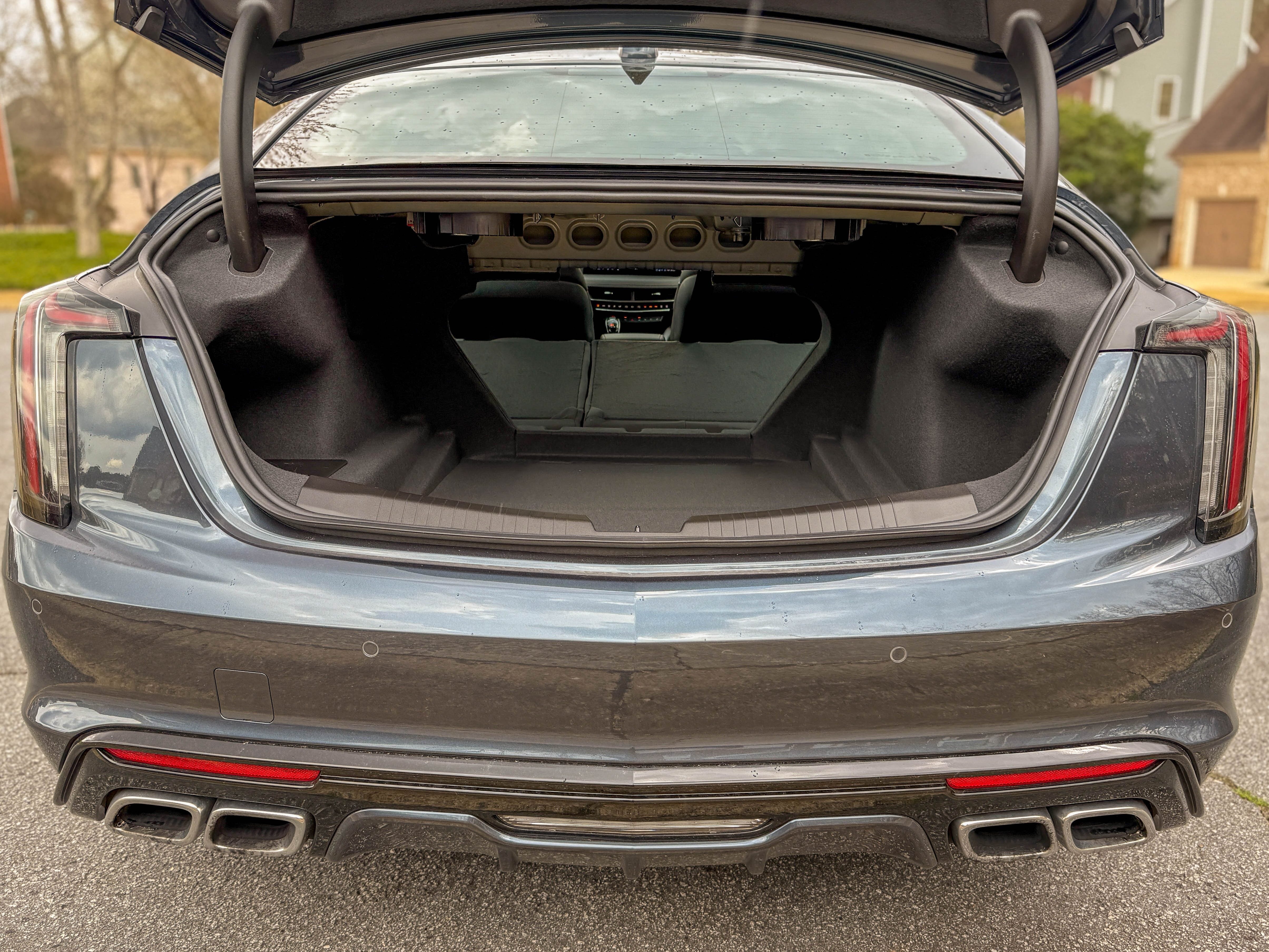 The open trunk of a gray 2025 Cadillac CT5-V sports sedan with the rear seats folded down.
