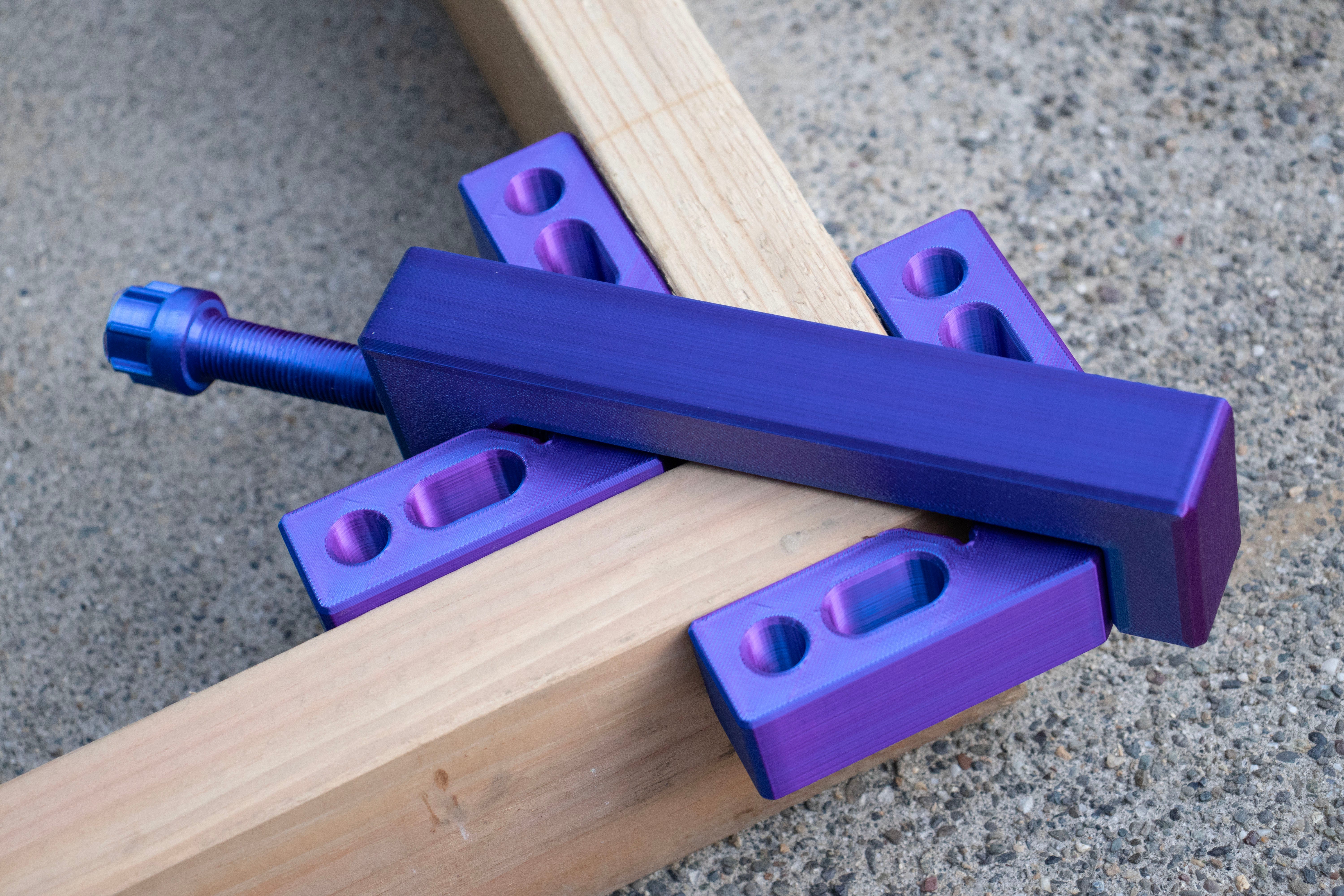a purple 3D printed clamp to hold wood planks in place
