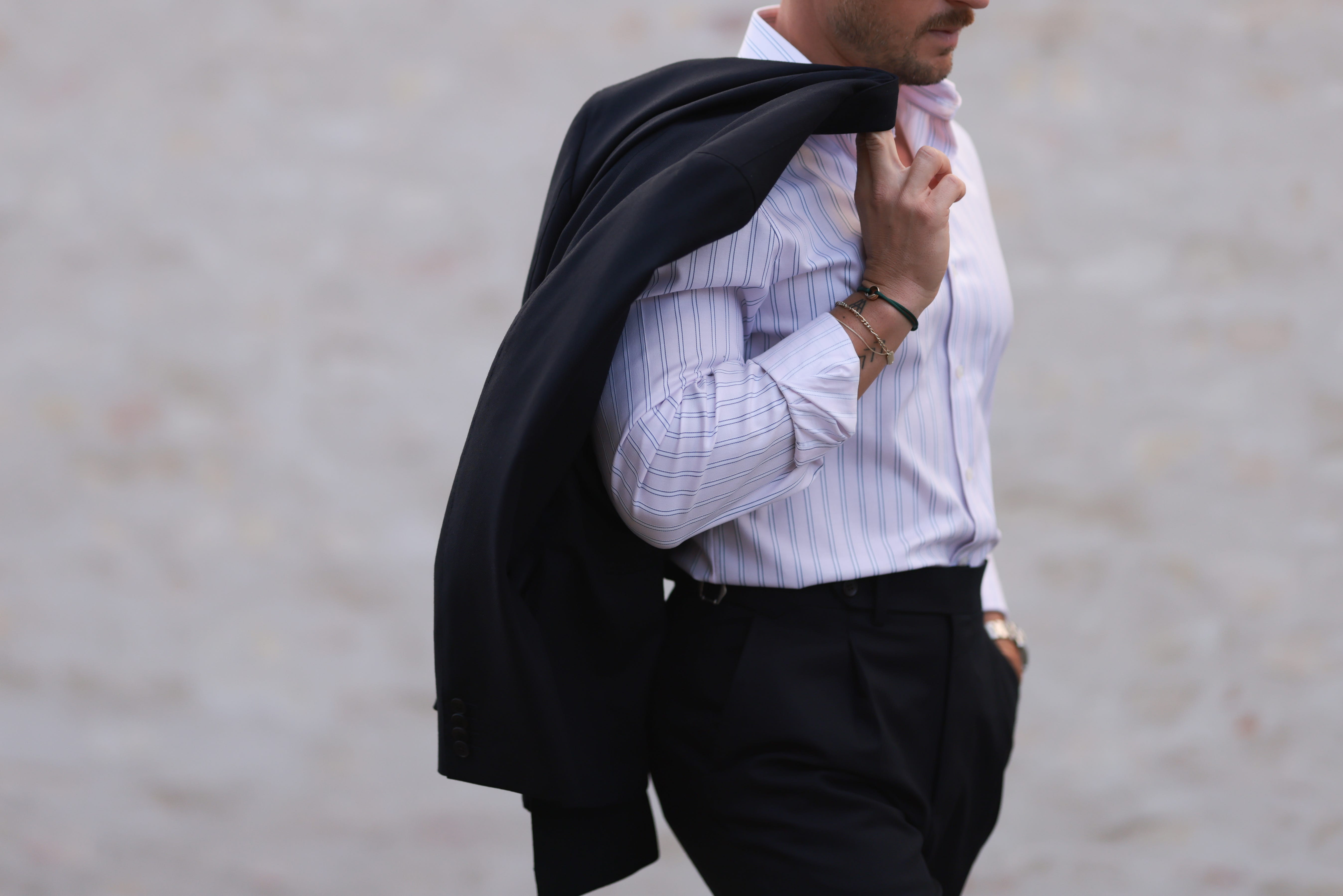Man holding jacket over shoulder in button down shirt