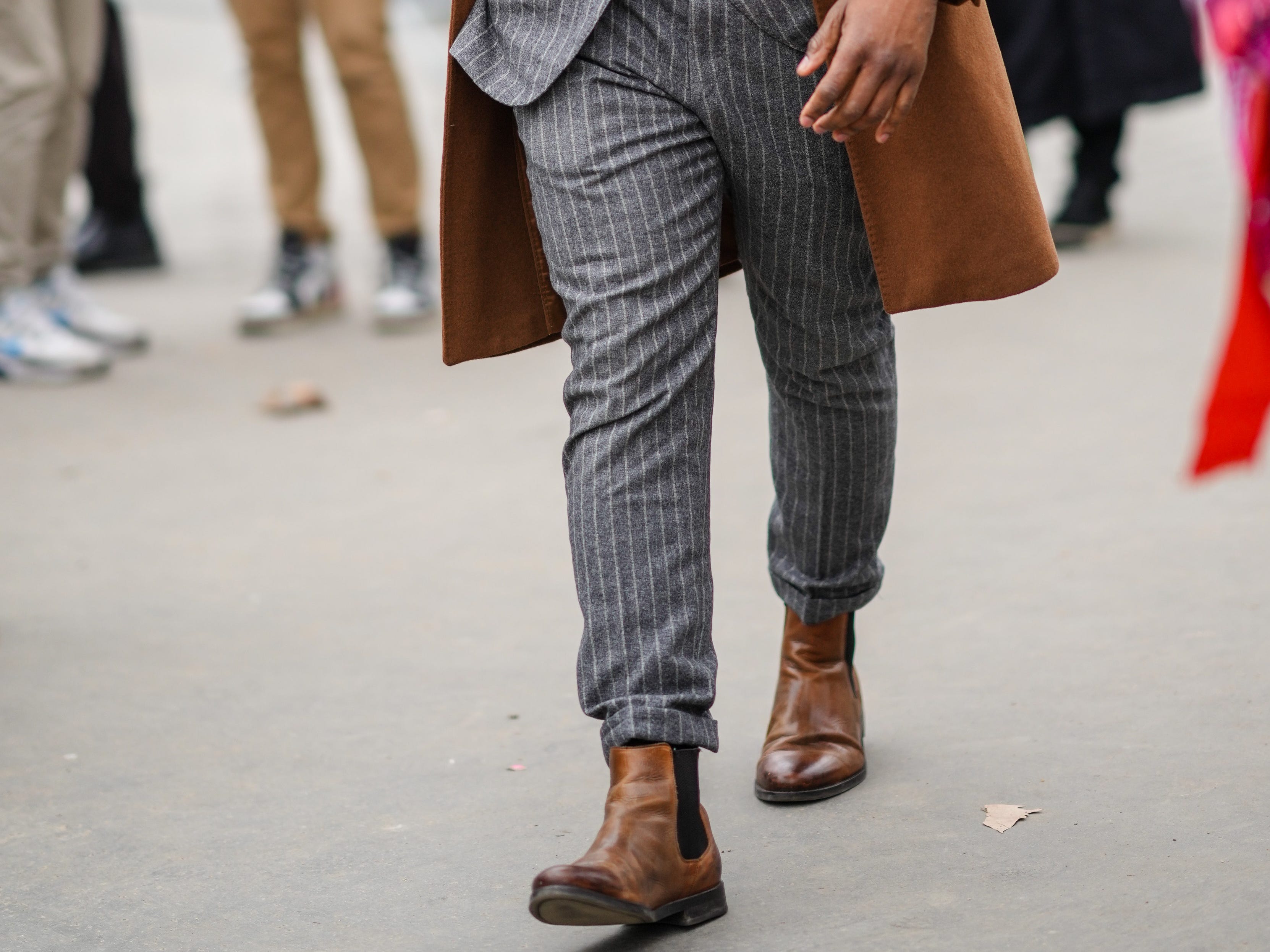 Man wearing pinstripe suit, chelsea boots, round sunglasses