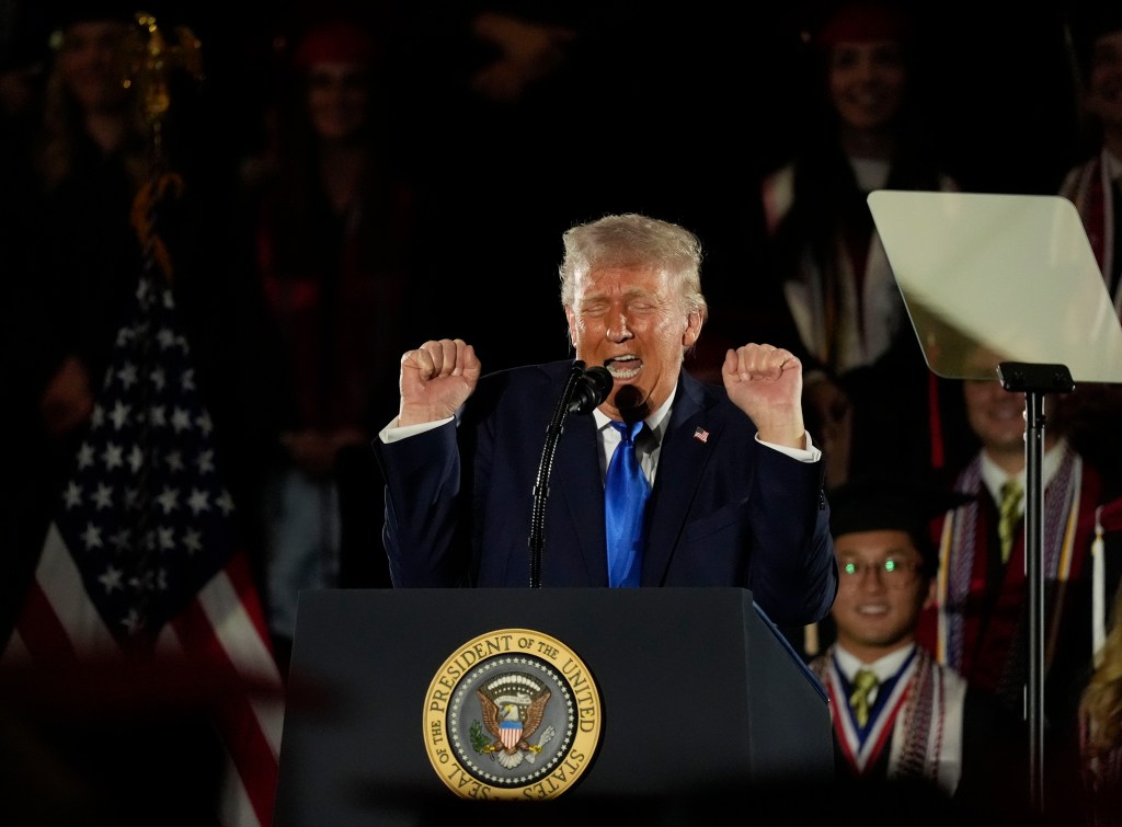 President Donald Trump shows off his impression of a weightlifter during his commencement address at the University of Alabama on May 1, 2025.