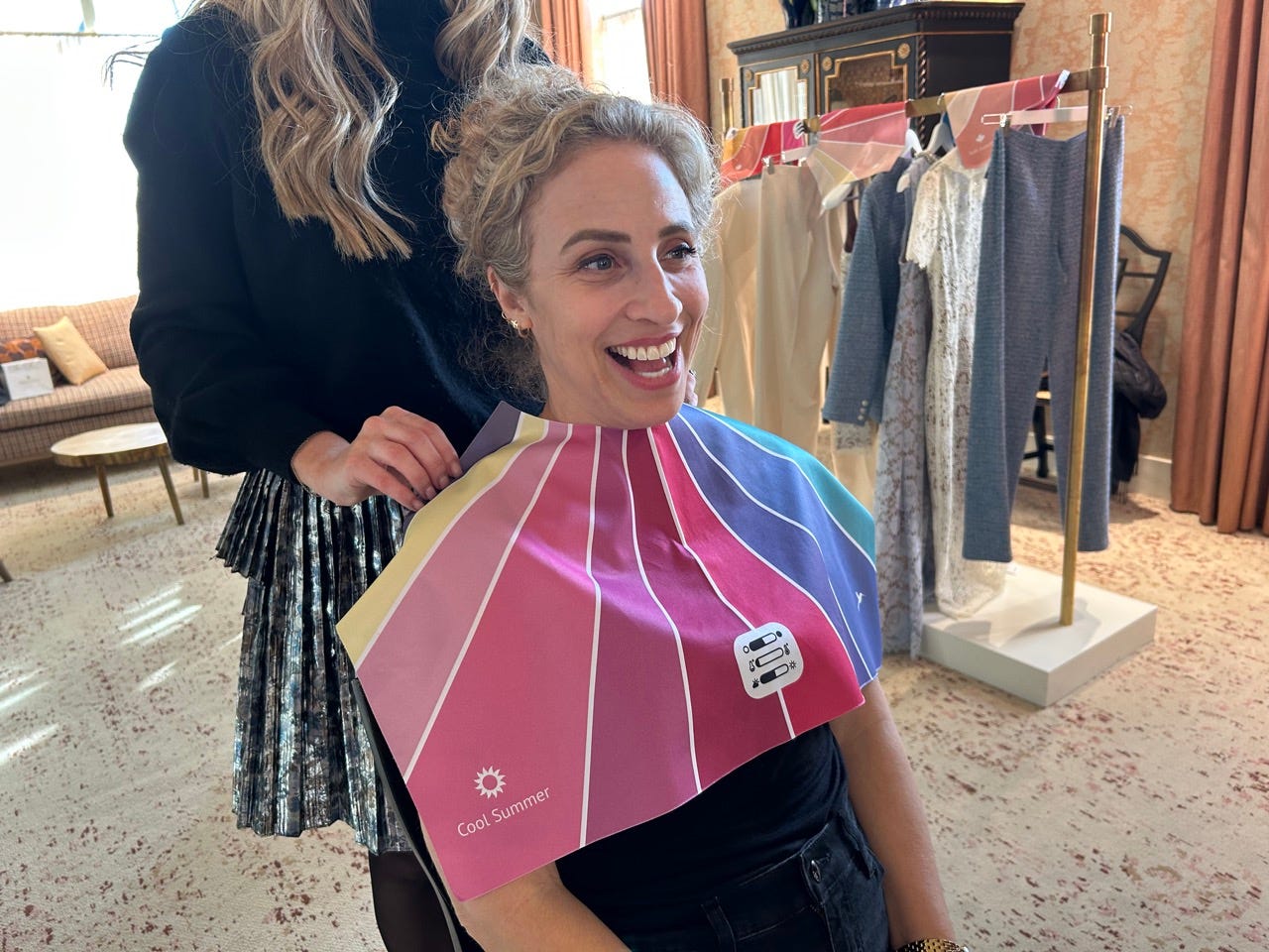 Author Alesandra Dubin smiling, wearing a colorful mat draped on her by stylist