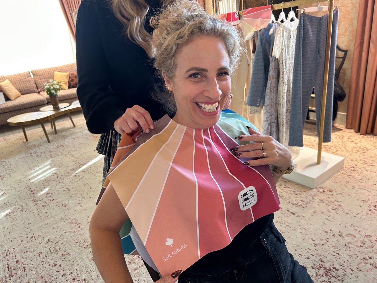 Author Alesandra Dubin smiling with soft autumn color palette draped around her