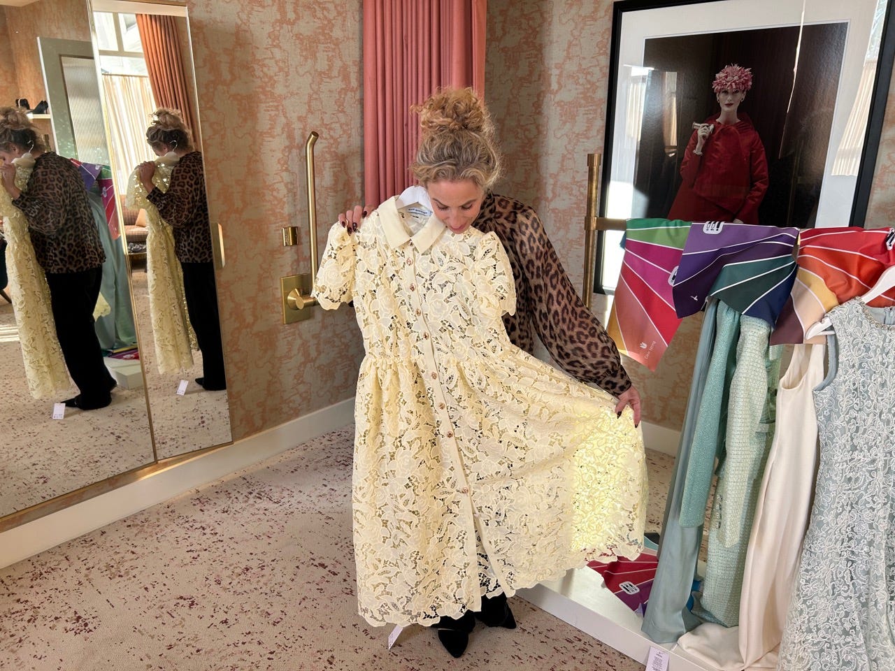 Author Alesandra Dubin holding a light yellow dress against her body