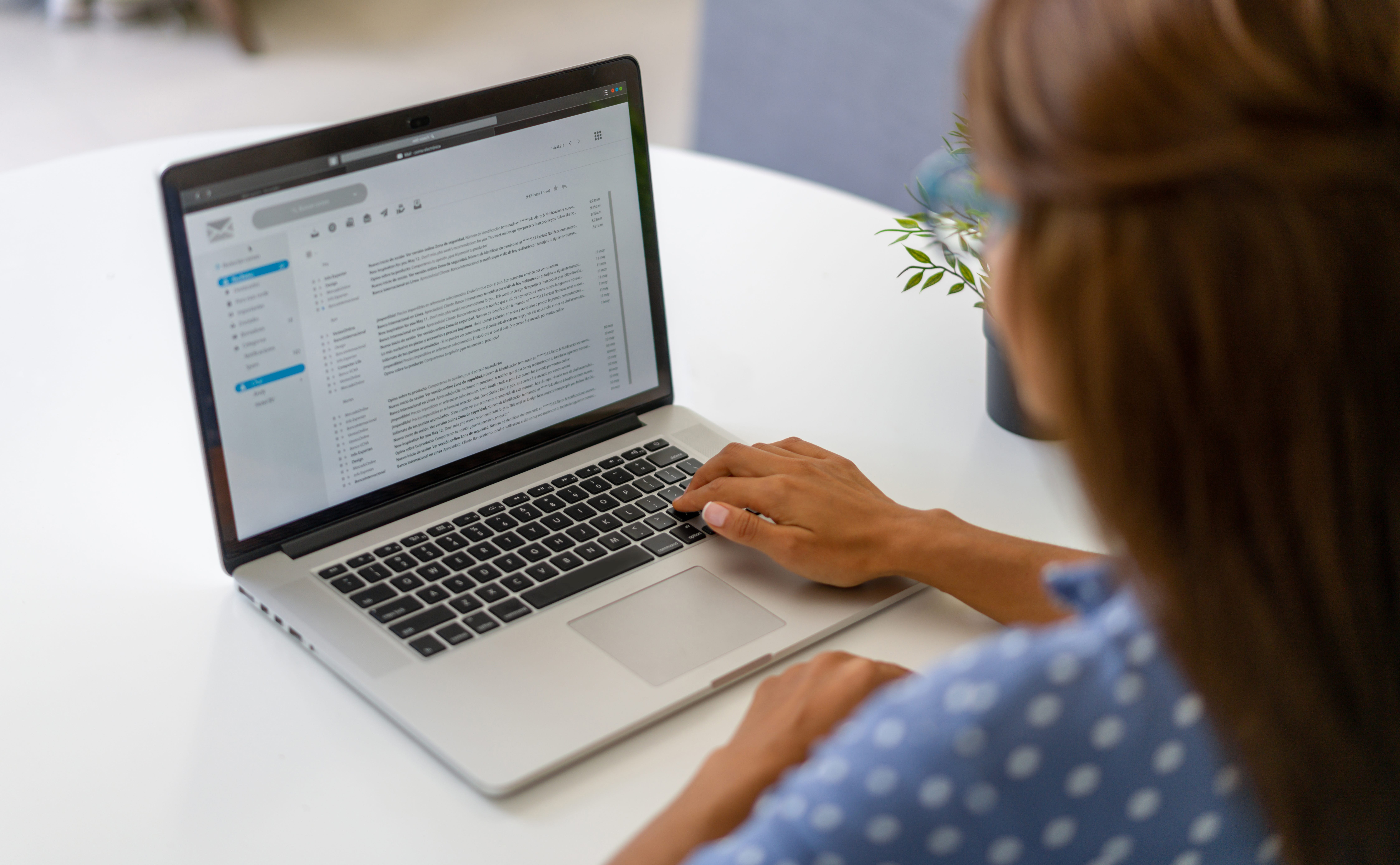 A woman reading emails on a laptop.