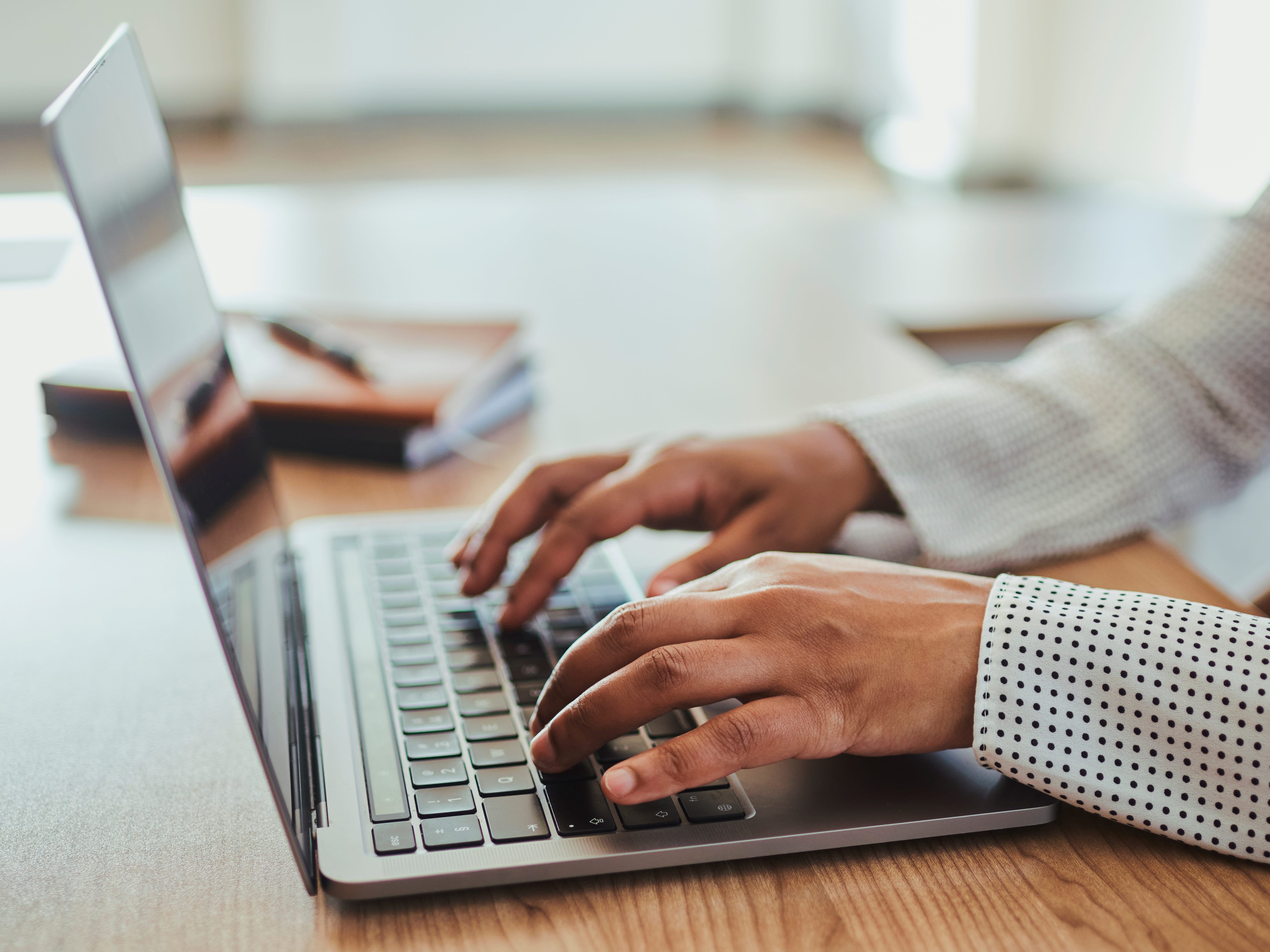 A woman typing on a laptop.